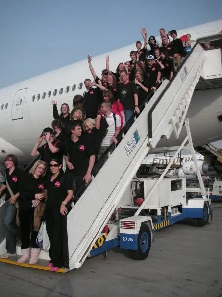 Archbishop Sentamu Academy students boarding an airplane, waving and smiling on a school trip organised by Teen Resilience Coach, Hayley Buchan.
