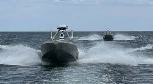 A speedboat moving quickly across the ocean, creating a large wake.