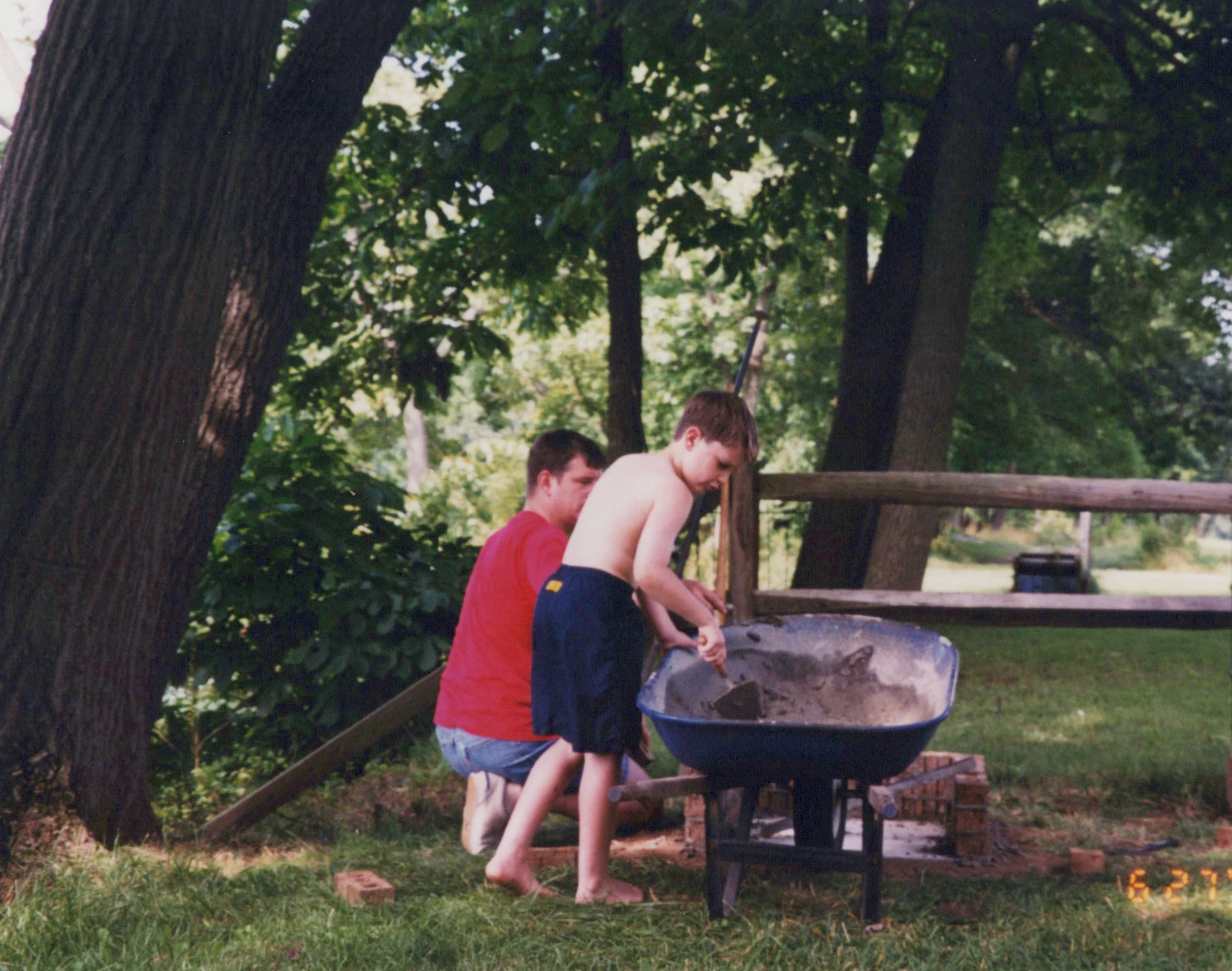 A vintage photo of Craig and his dad, Gary, working on a homemade brick firepit along the Potomac River.