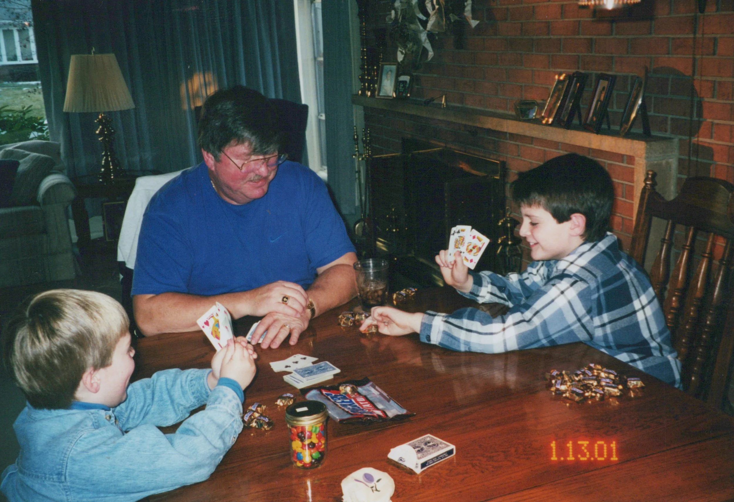 An old photo of Craig as a child with his brother playing cards with their grandfather