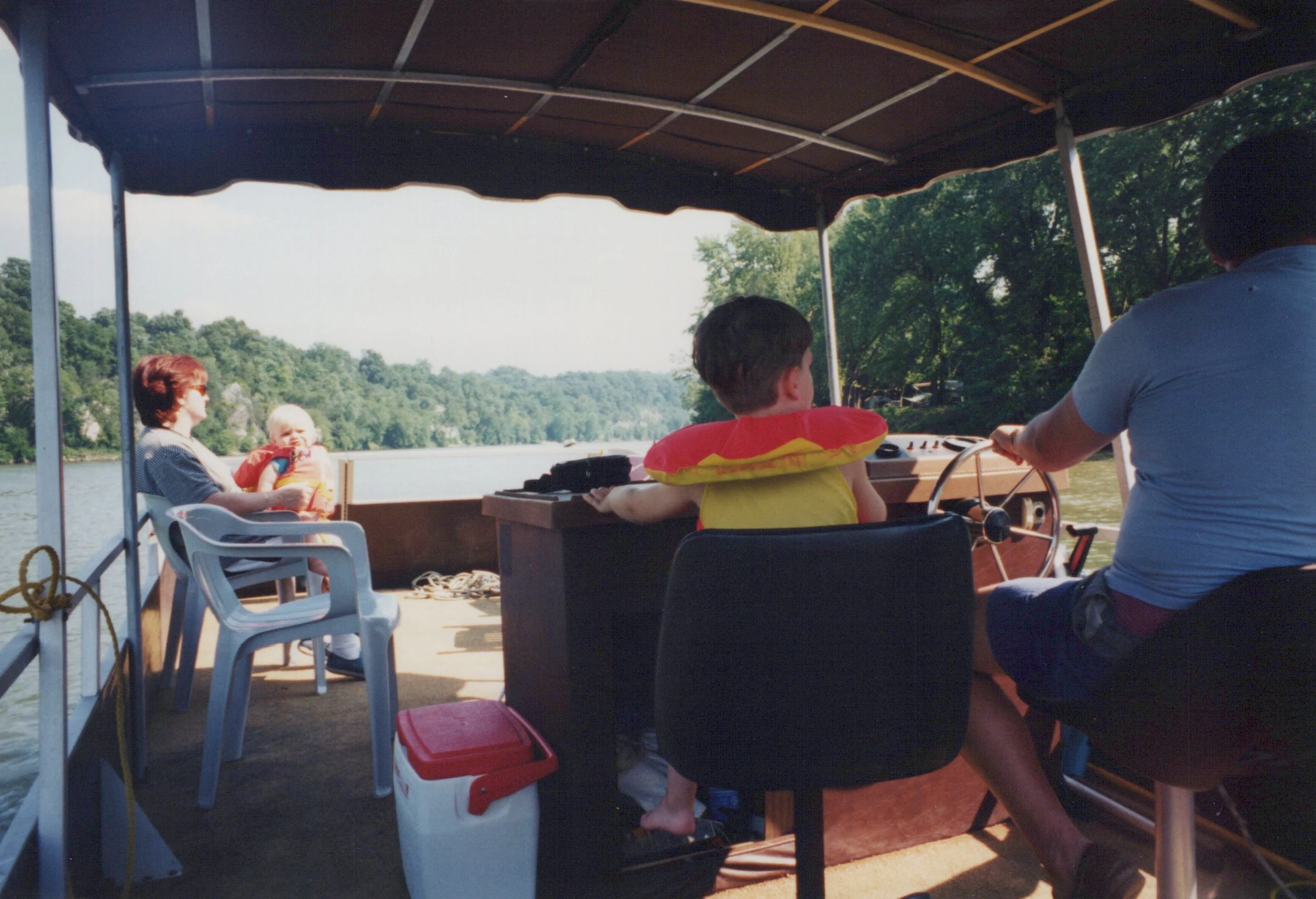 An old photo of Craig as a child on a pontoon boat with his mother, brother, and grandfather on the Potomac River