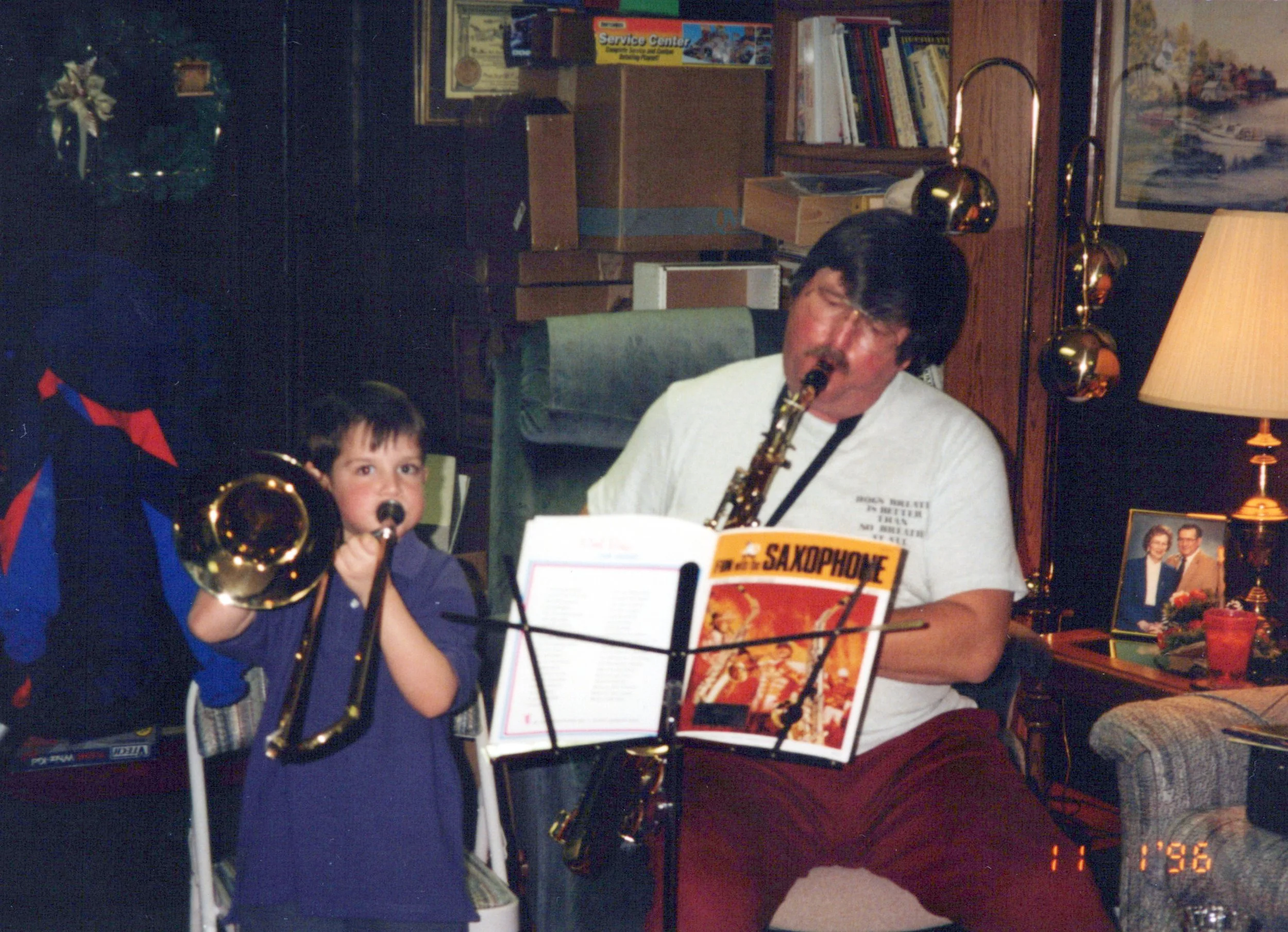 An old photo of Craig as a child playing the trombone while his grandfather plays the tenor saxophone