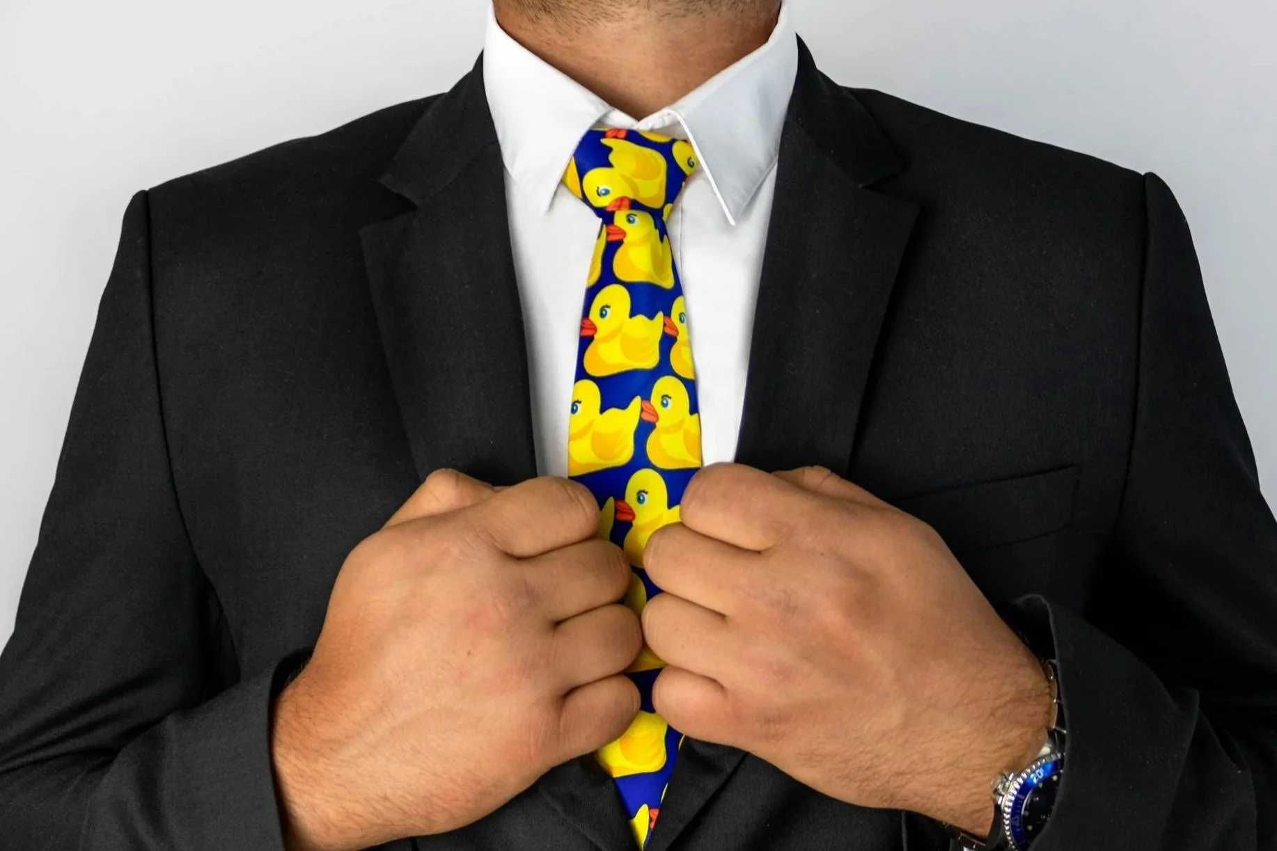 a man dressed in a suit but wearing a yellow ducks tie