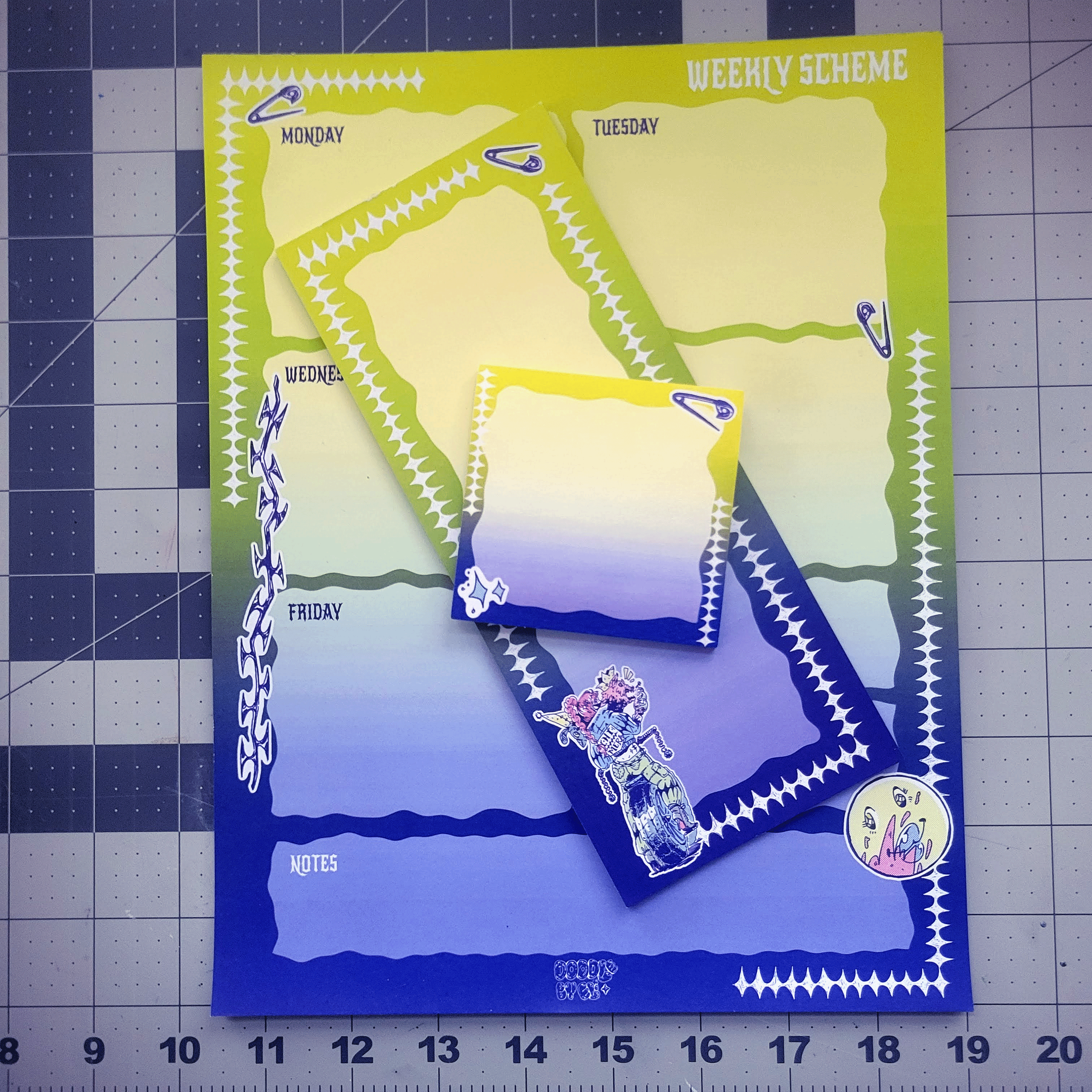Colorful weekly planner and note sheets featuring a girl illustration, with sections for each weekday and notes, decorated with zigzag borders and stickers, placed on a cutting mat background.