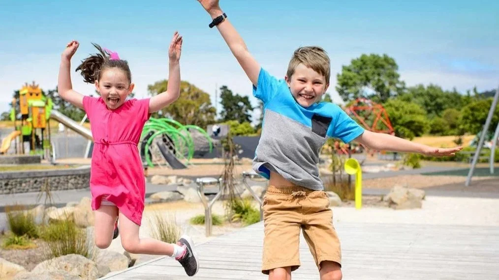 Two kids jumping and playing in Avalon Park, located in Lower Hutt NZ
