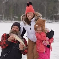Fishing Guide Jason Heindl teaching children how to ice fish for walleye in Minocqua Wisconsin.