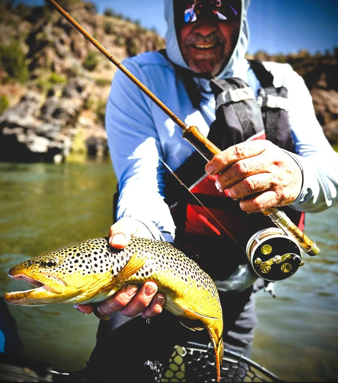 Angler holding a 20-inch brown trout and a 6-weight Lake Fork Rods bamboo ferrule fly rod in the Black Canyon of the Gunnison River