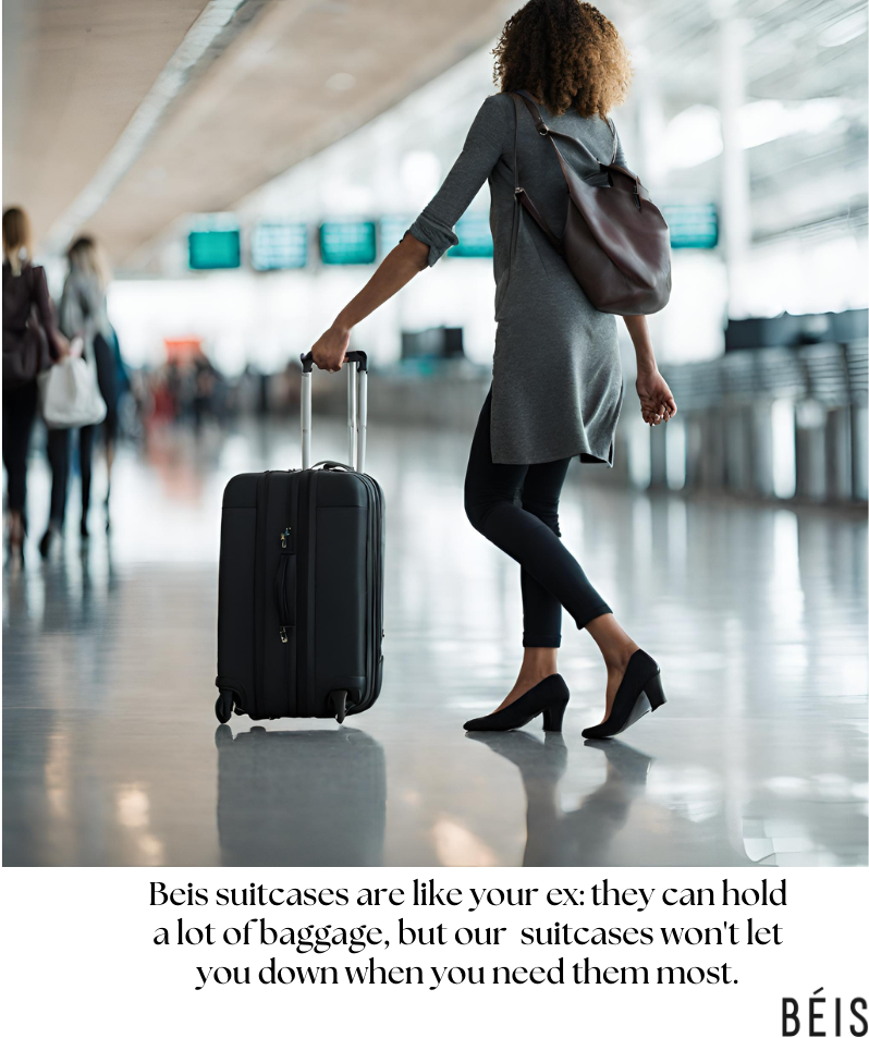 A woman walking through an airport terminal pulling a black suitcase. She is wearing a gray coat, black pants, and high heels, with a large brown bag over her shoulder. There are other travelers in the background and digital departure screens above.