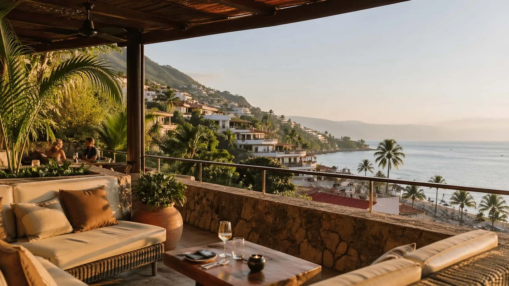 Open-air coastal terrace overlooking Banderas Bay, palm trees, and the hillside architecture of Puerto Vallarta in warm afternoon light.