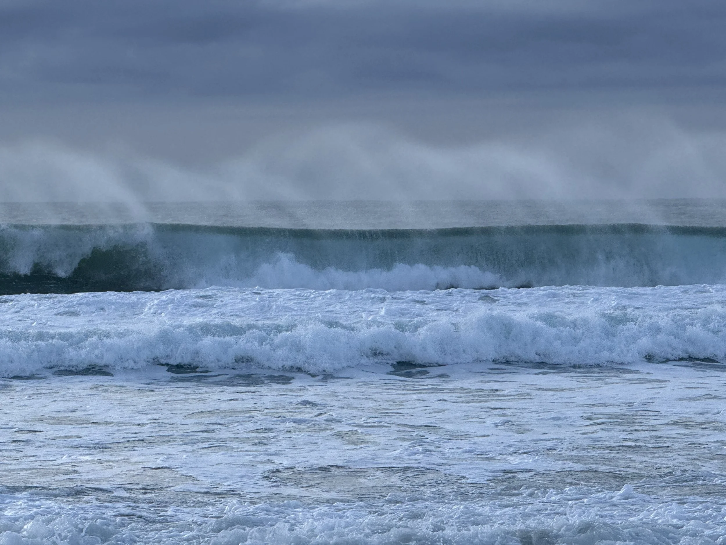 Atlantic ocean waves crashing under a cloudy sky. Photo by Susan Marte