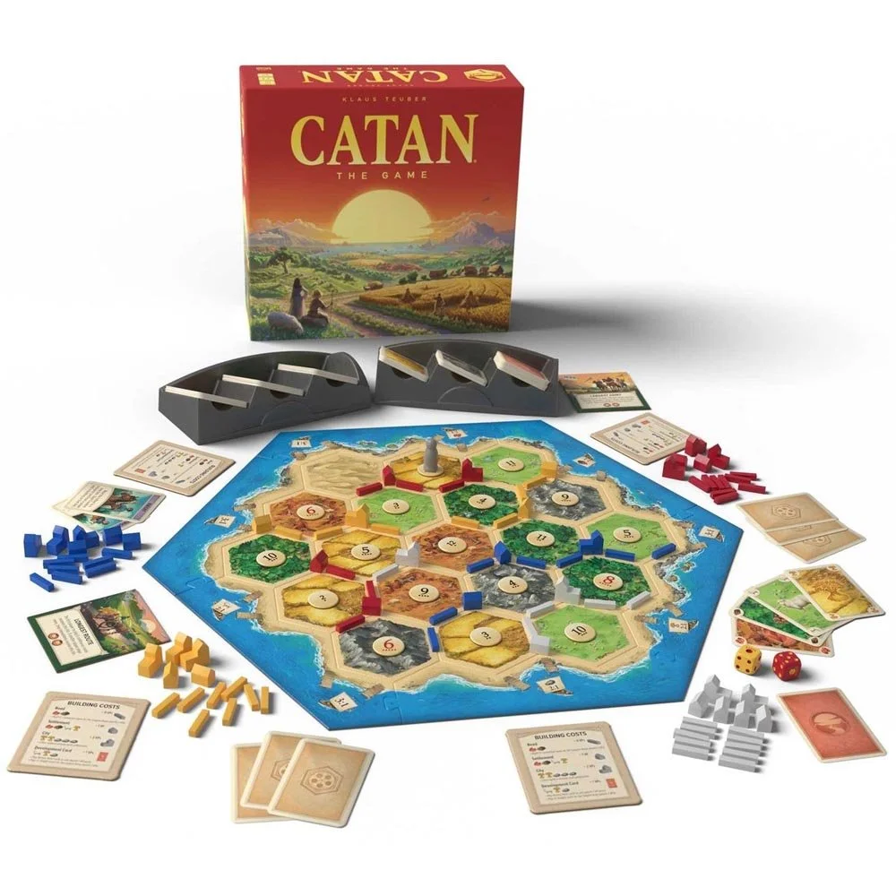 Billedet viser spillet Catan med brikker, kort, terninger og spillebrikker lagt ud på et bord.