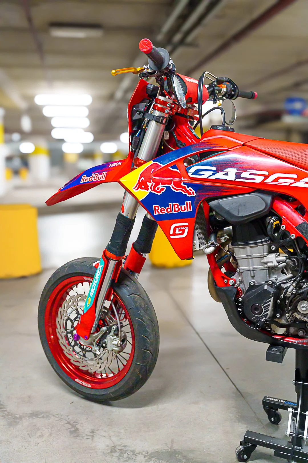 Motocicletta da cross rossa con sponsor Red Bull e GasGas, parcheggiata in un garage