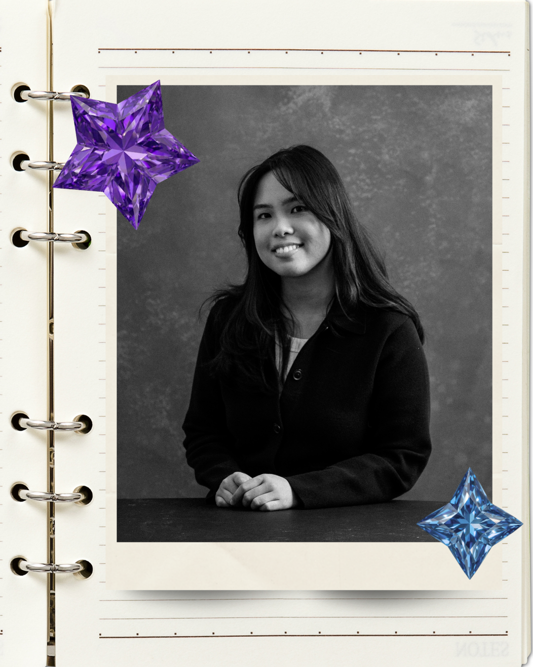 Black and white portrait of a young woman smiling, in a notebook with purple and blue decorative gemstones.