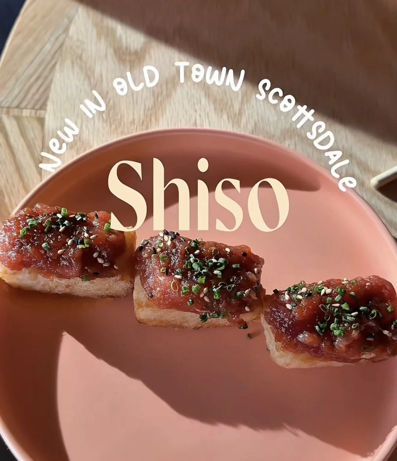 A pink plate holding three pieces of toast topped with a red sauce, green onions, and sesame seeds. Text on the image reads "Shiso" with the phrase "New in Old Town Scottsdale" circling around the top.