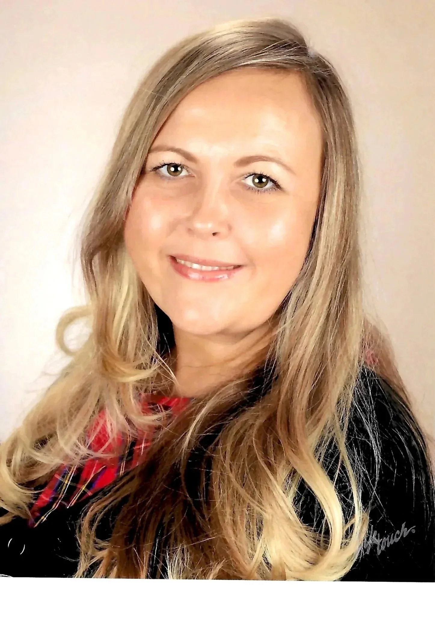 A woman with long blonde hair smiling at the camera.