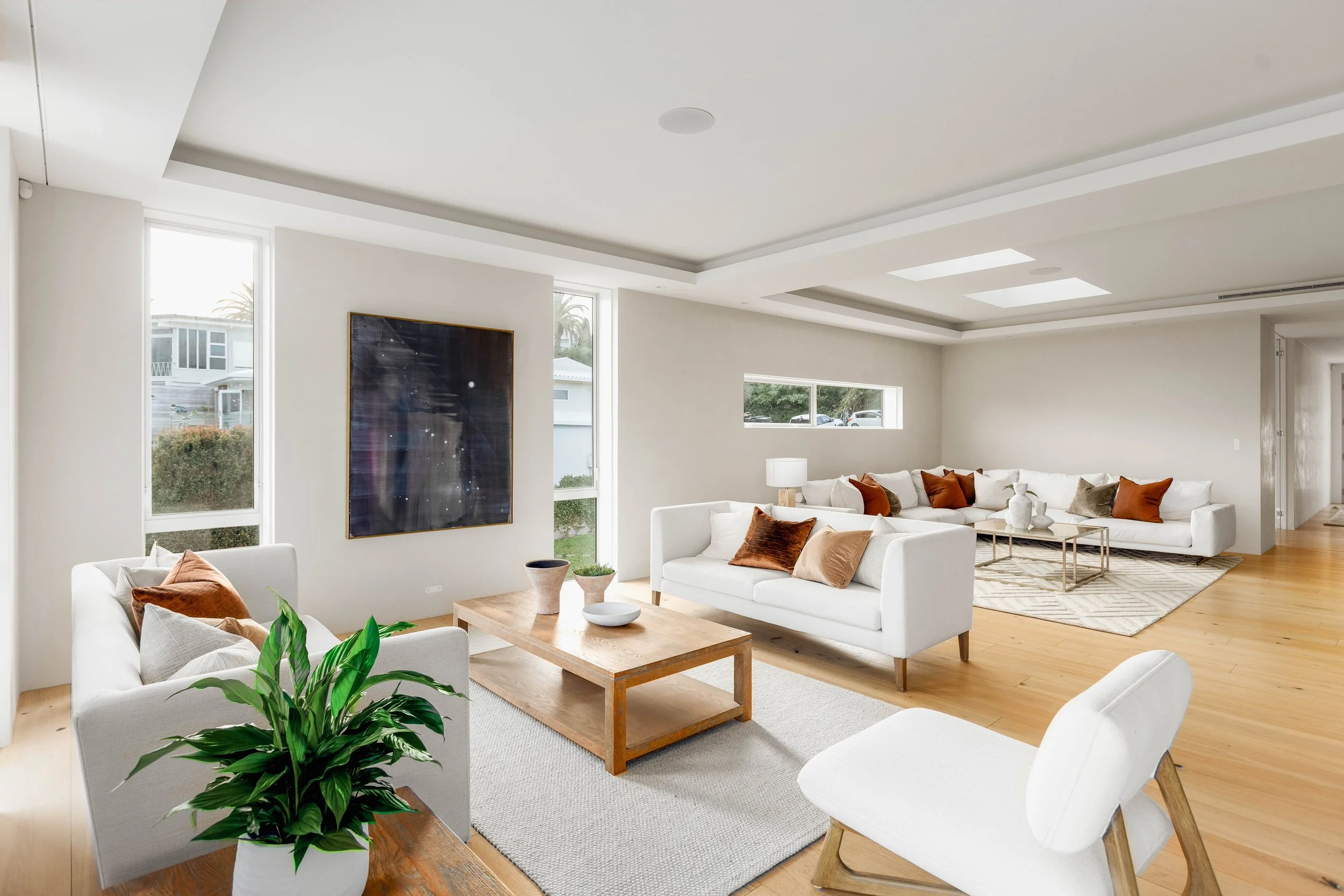 St Heliers luxury living room, Auckland Eastern Bays, with architectural scale, skylights, European oak flooring, and premium lighting, part of a high-end coastal residence.