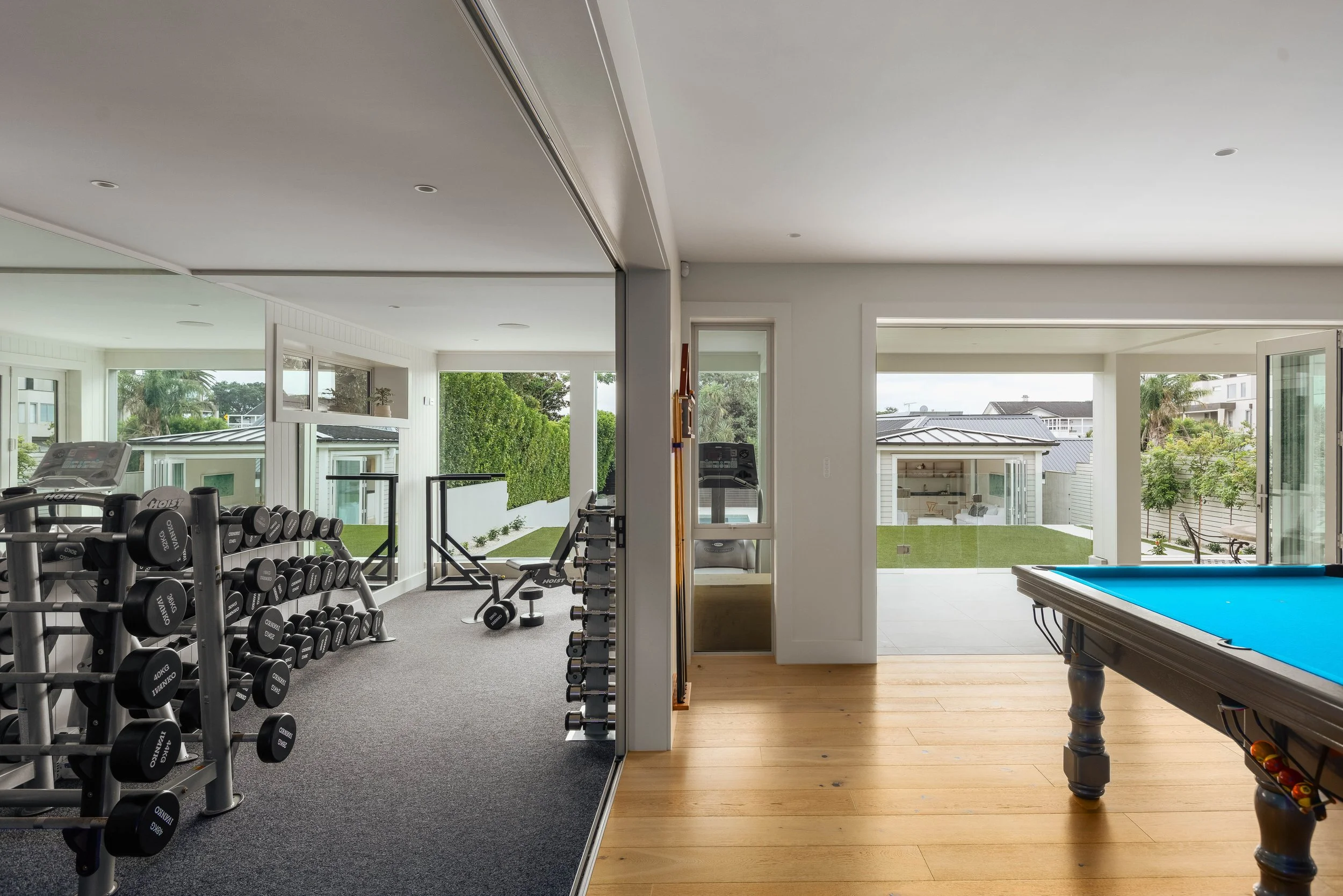 St Heliers luxury home gym Auckland Eastern Bays overlooking pool and games room, part of a high-end coastal property with integrated wellness and entertainment spaces.