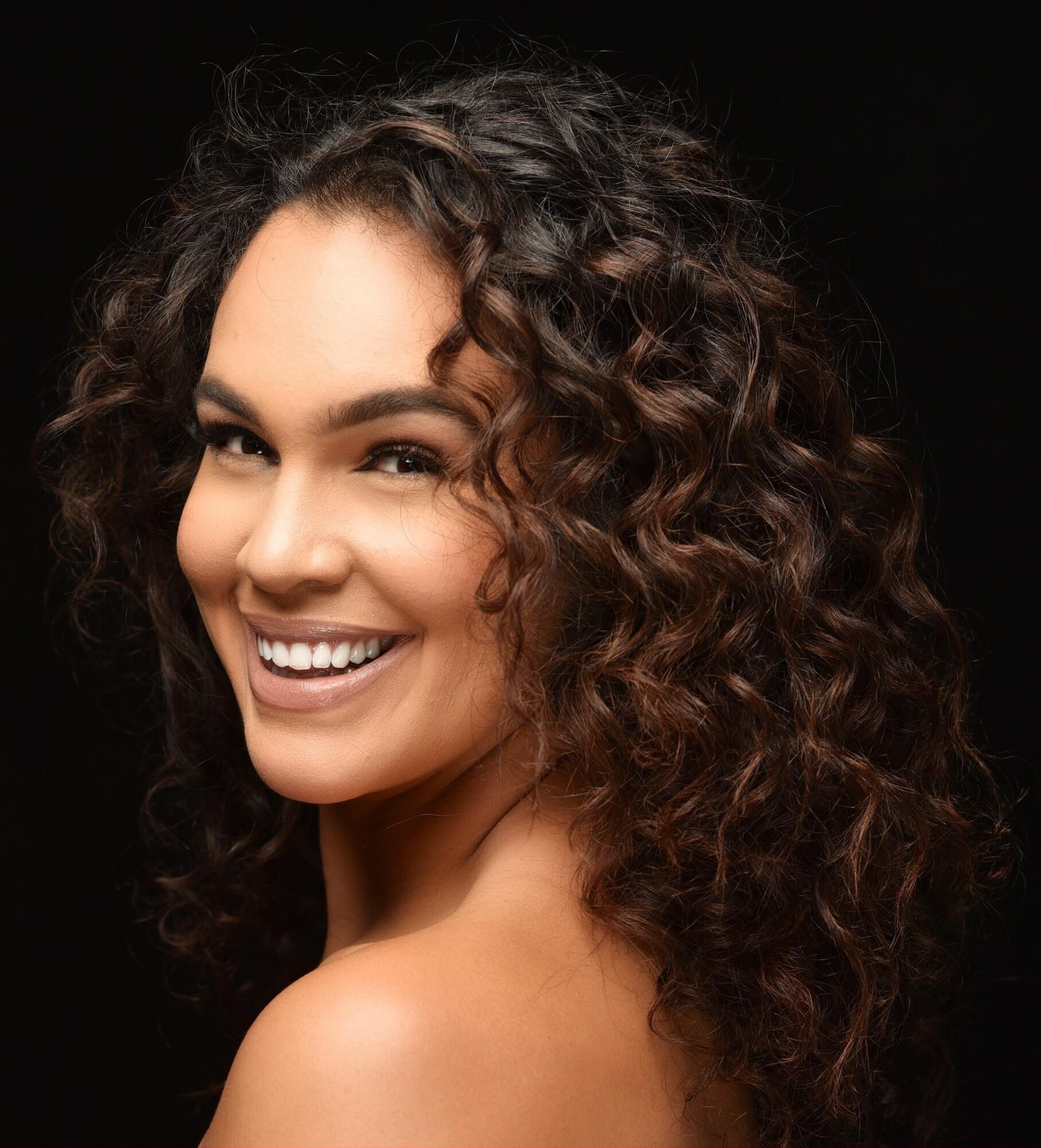 Dariana Casado -  portrait looking over shoulder smiling long curly hair