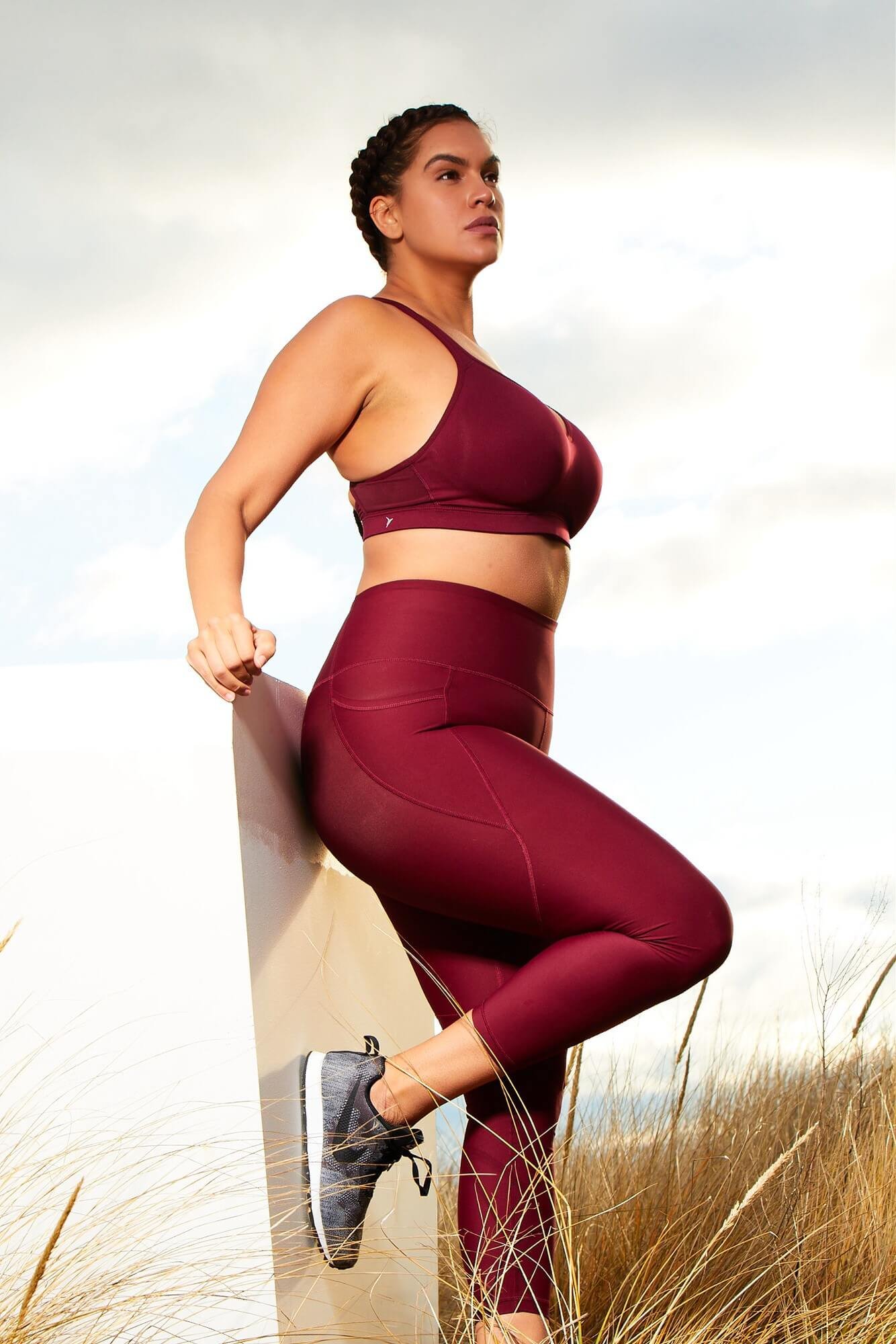 wellness for women - Dariana Casado - in burgundy workout gear and long braids