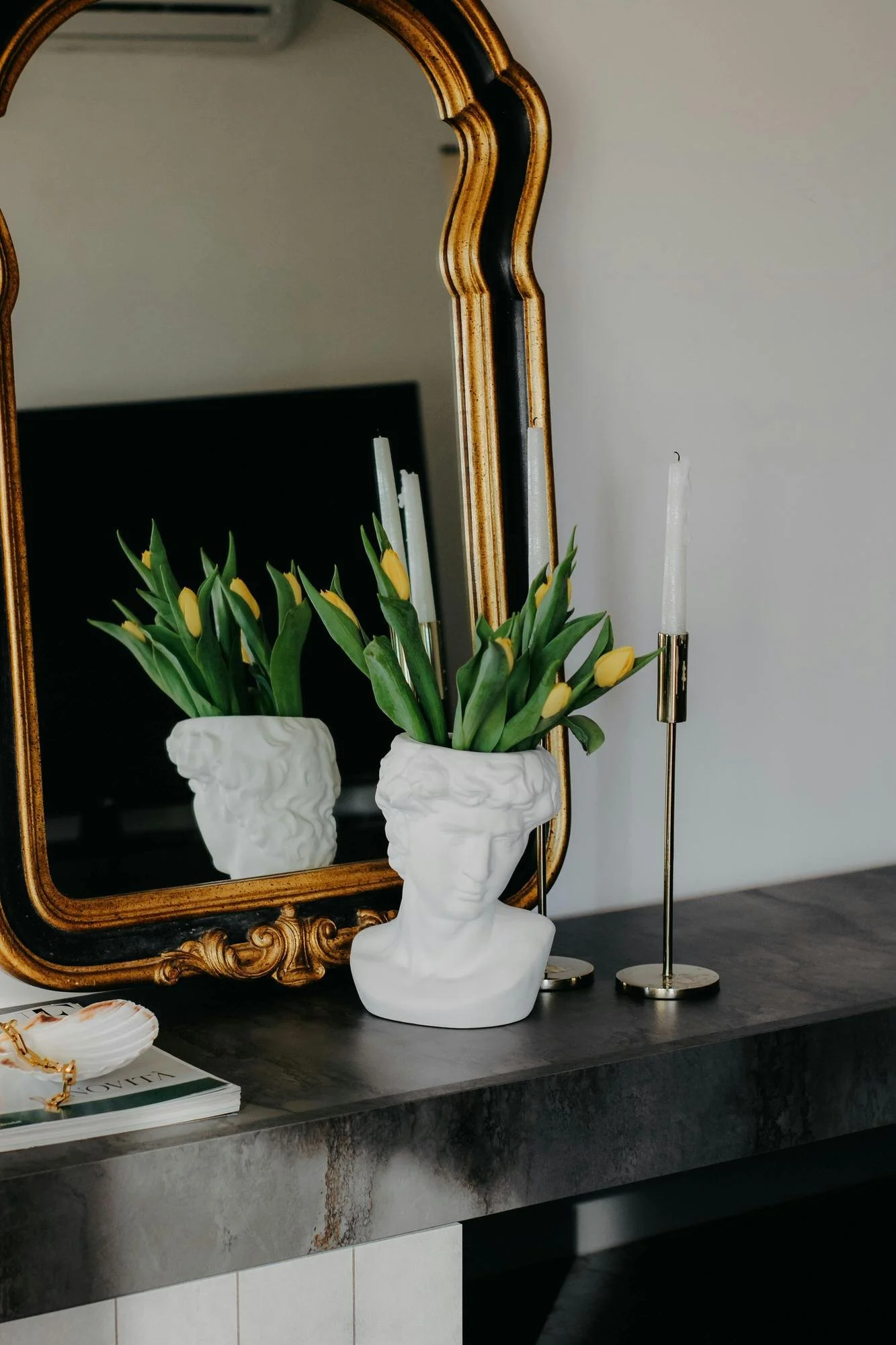 entry way table with vase and tulips and gold mirror