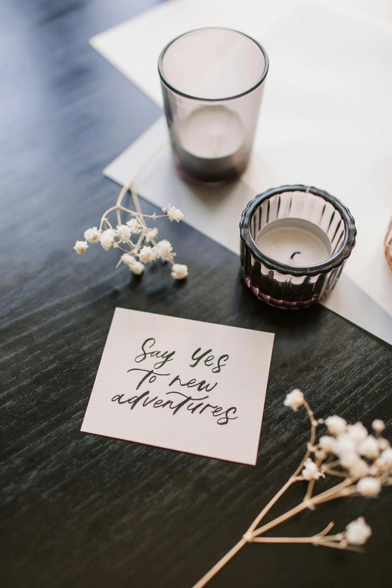 table with note, candles, and flower sprigs