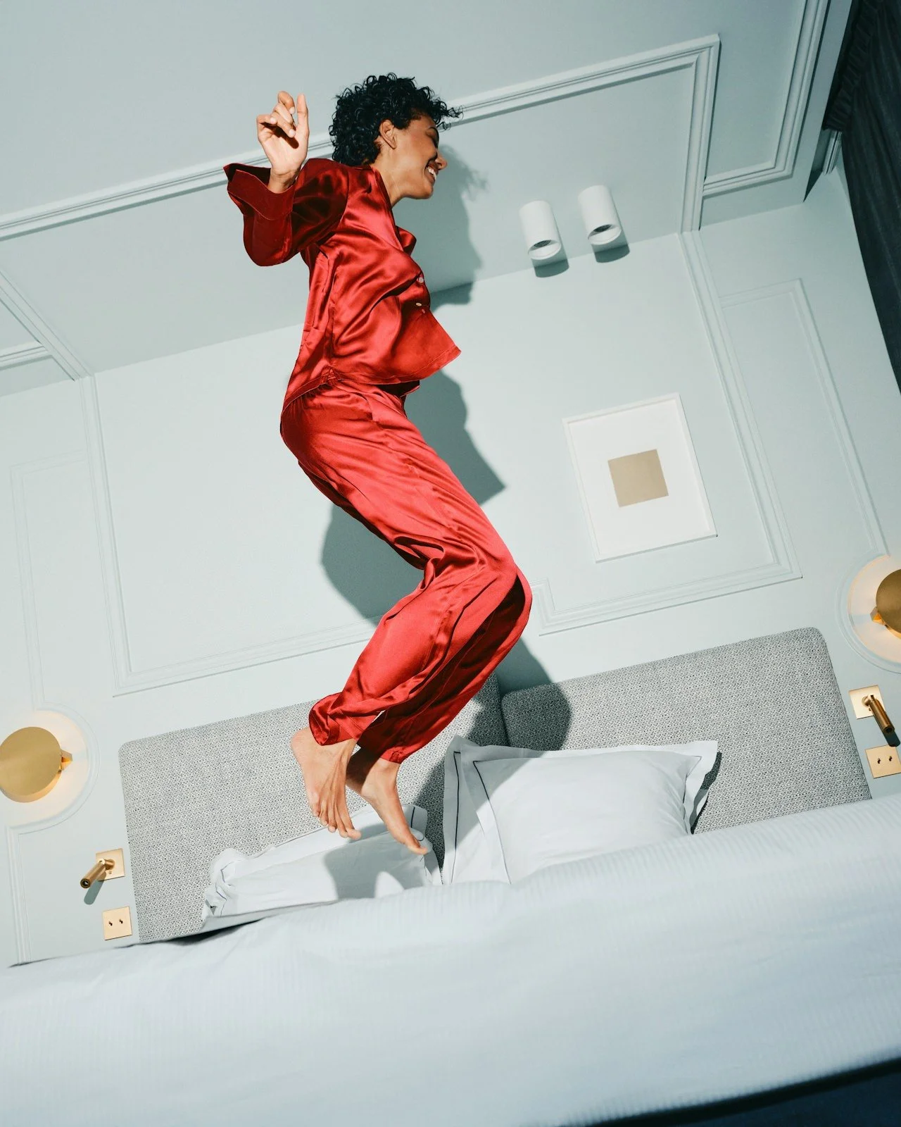 woman in red pjs, jumping on bed