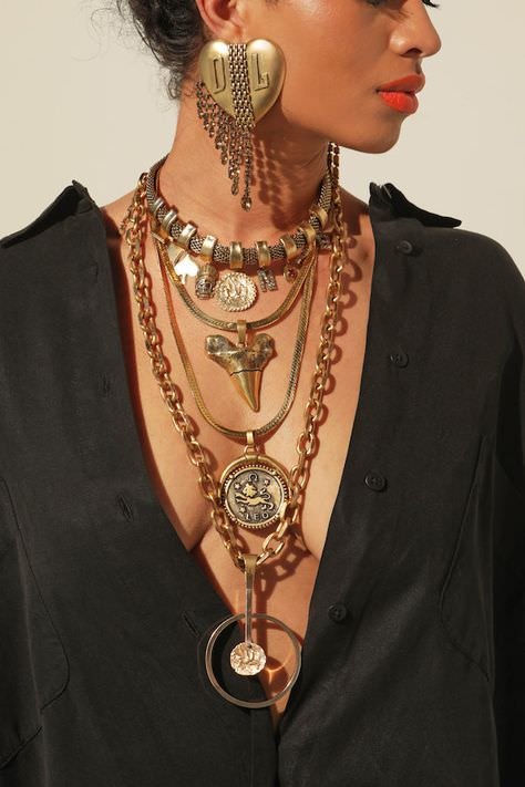 woman face turned with red lips, bold jewelry, black top