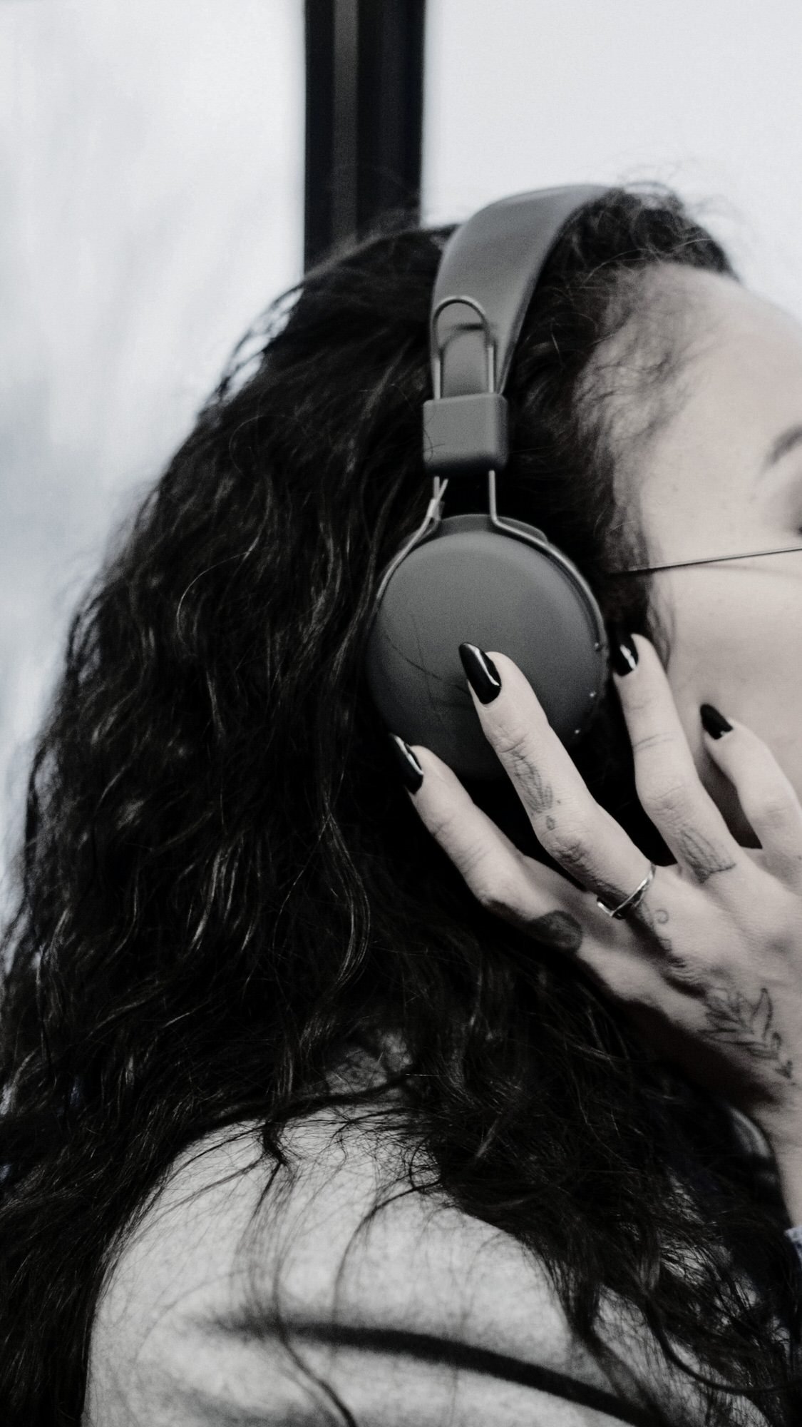 woman with headphones one holding headphones with hand