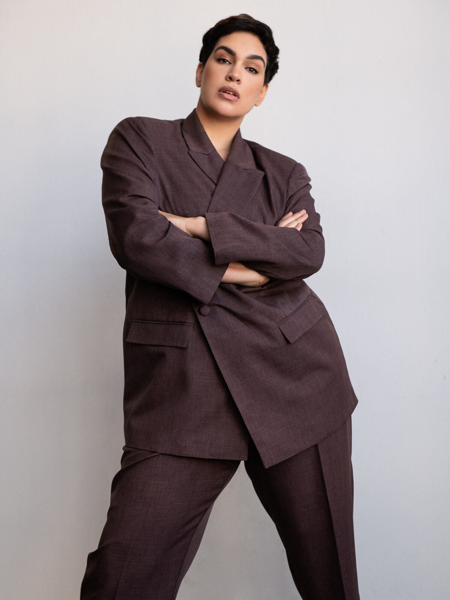 Dariana Casado - creative portrait in plum suit arms crossed