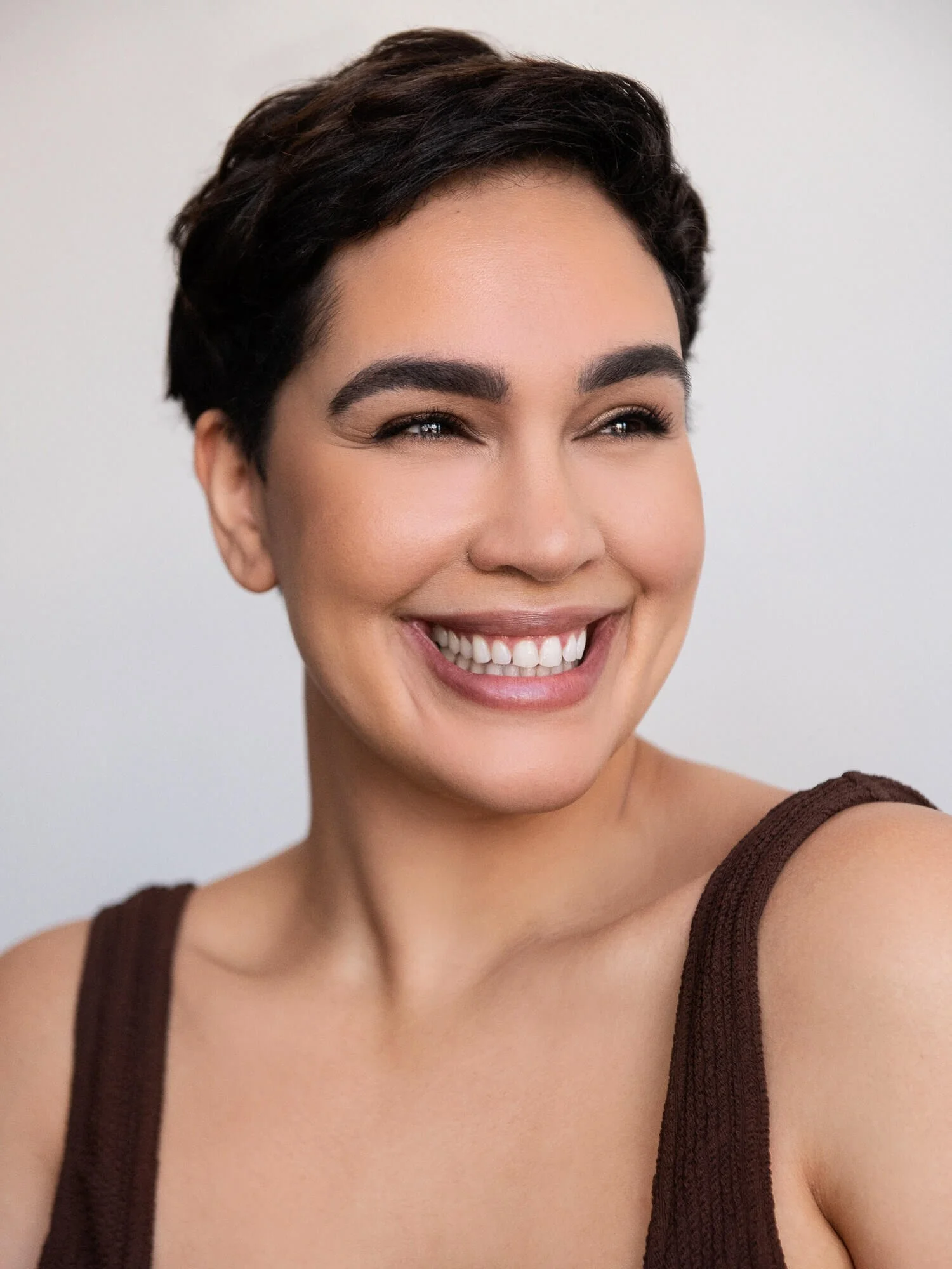 Dariana Casado - headshot, smiling in brown tank top