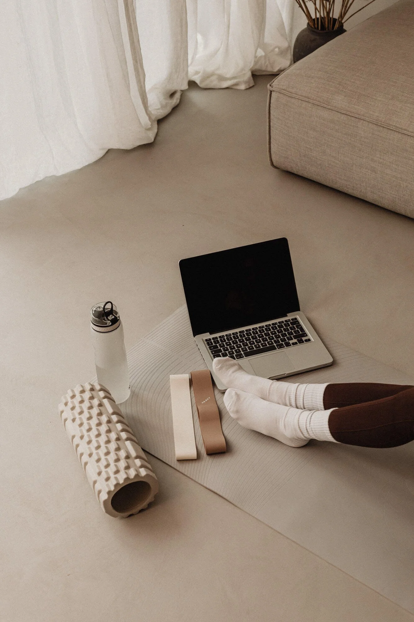 laptop, ypga mat, water bottle, ypga gear and woman's feet