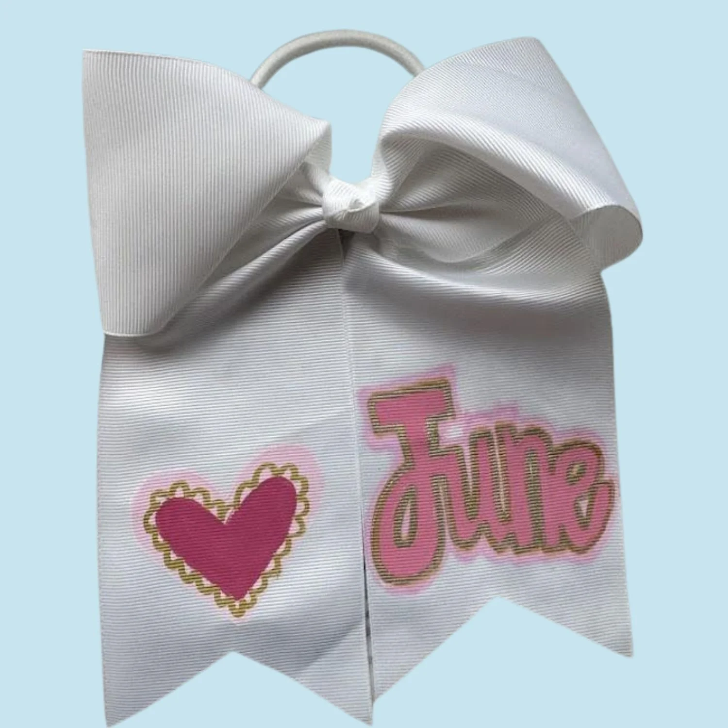 White ribbon bow with pink and gold customization, featuring a pink heart and the name 'June'.