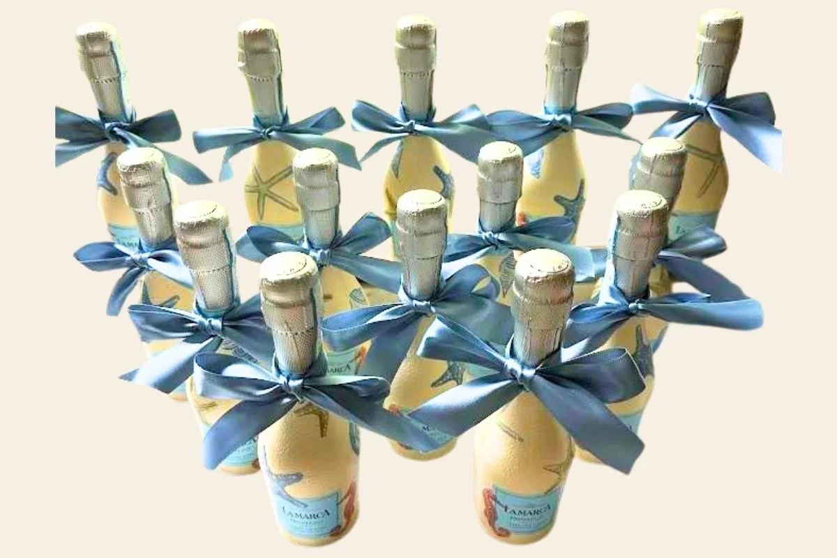 Several bottles of champagne decorated with blue ribbons, arranged in a pattern.