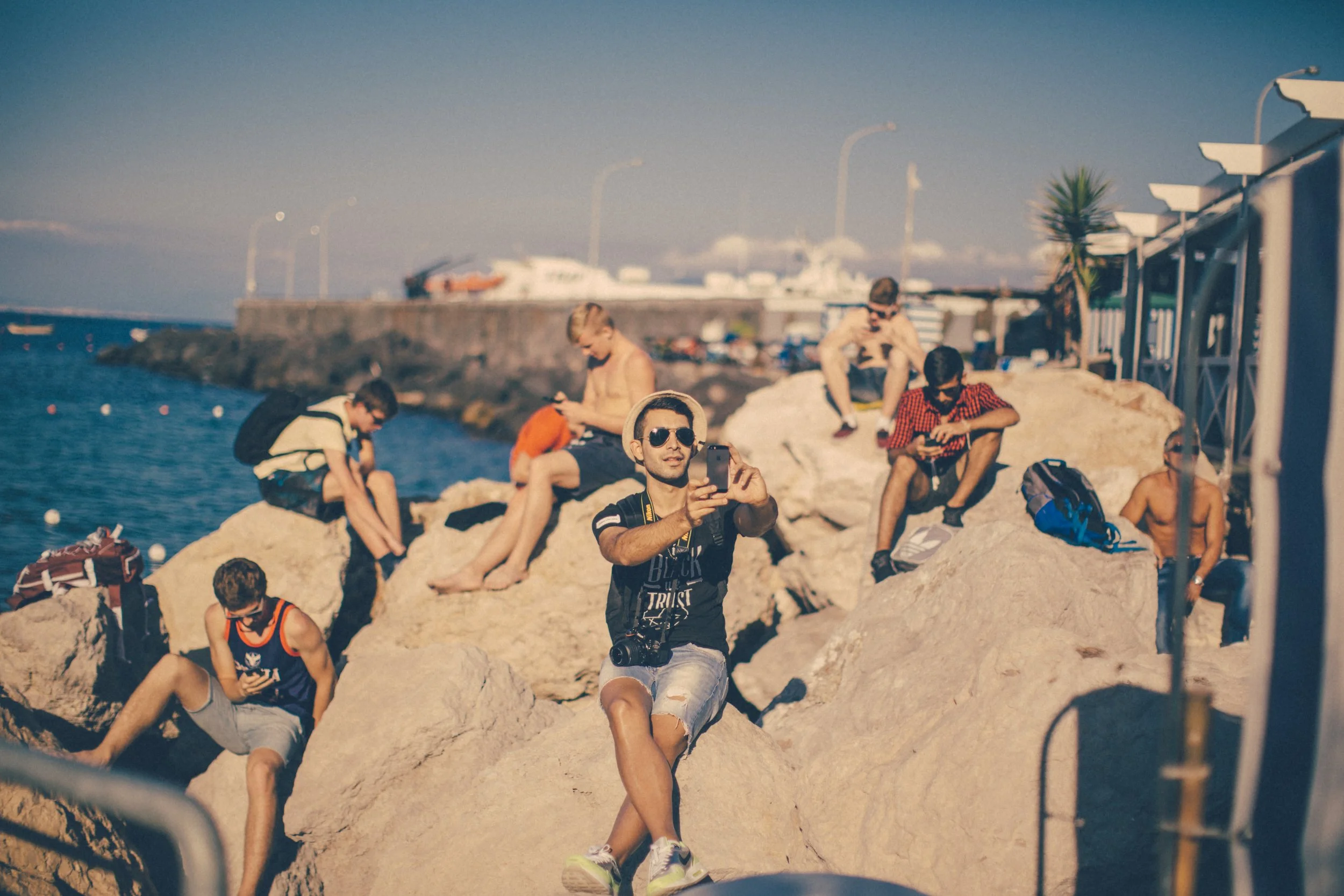 Beach scene in Capri Italy everyone looking at cellphone screens candid portrait Simon Shattky
