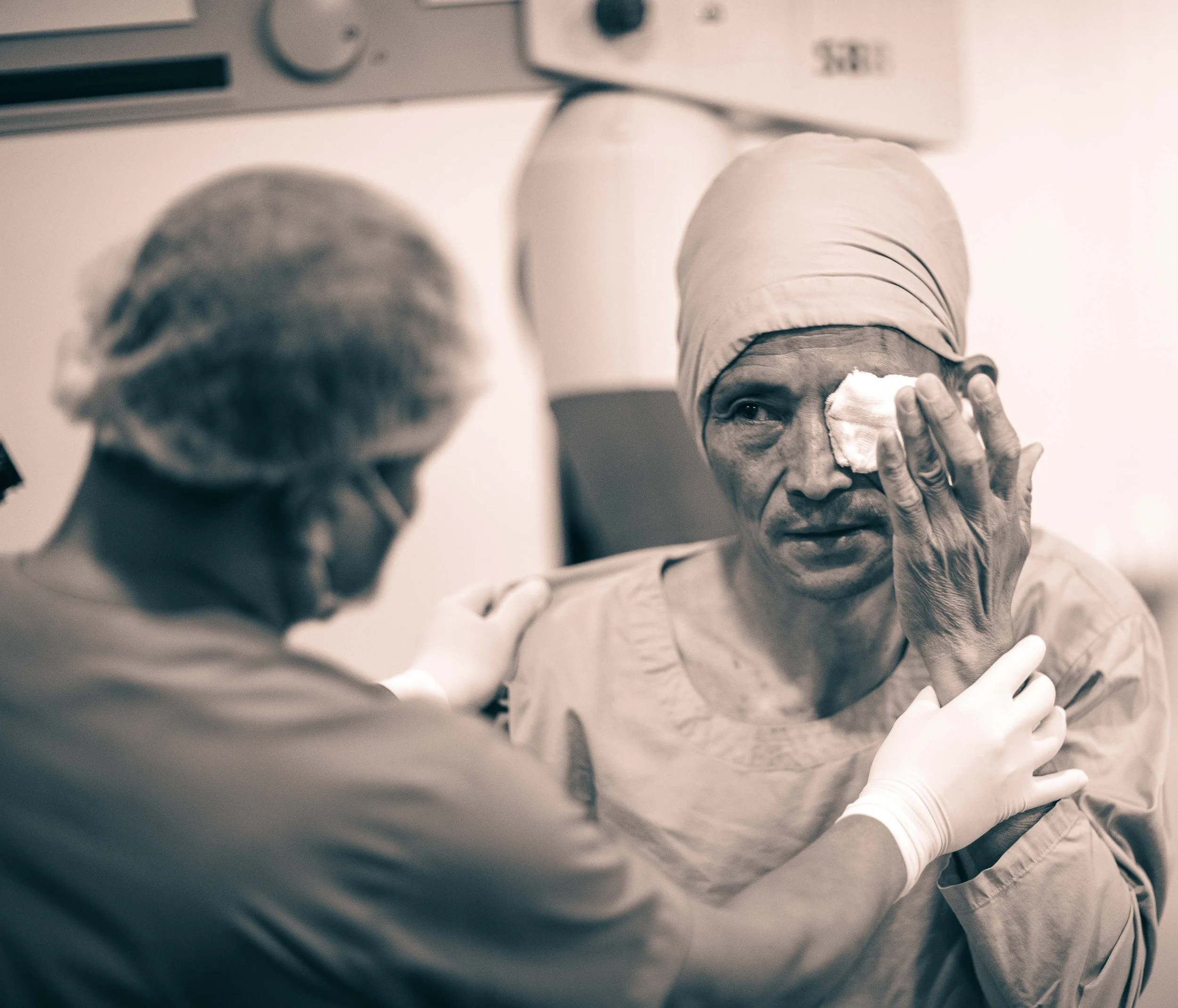candid editorial black and white photograph Post surgery cataract patient eye dressing being applied Tilganga Eye Institute Kathmandu Nepal Simon Shattky
