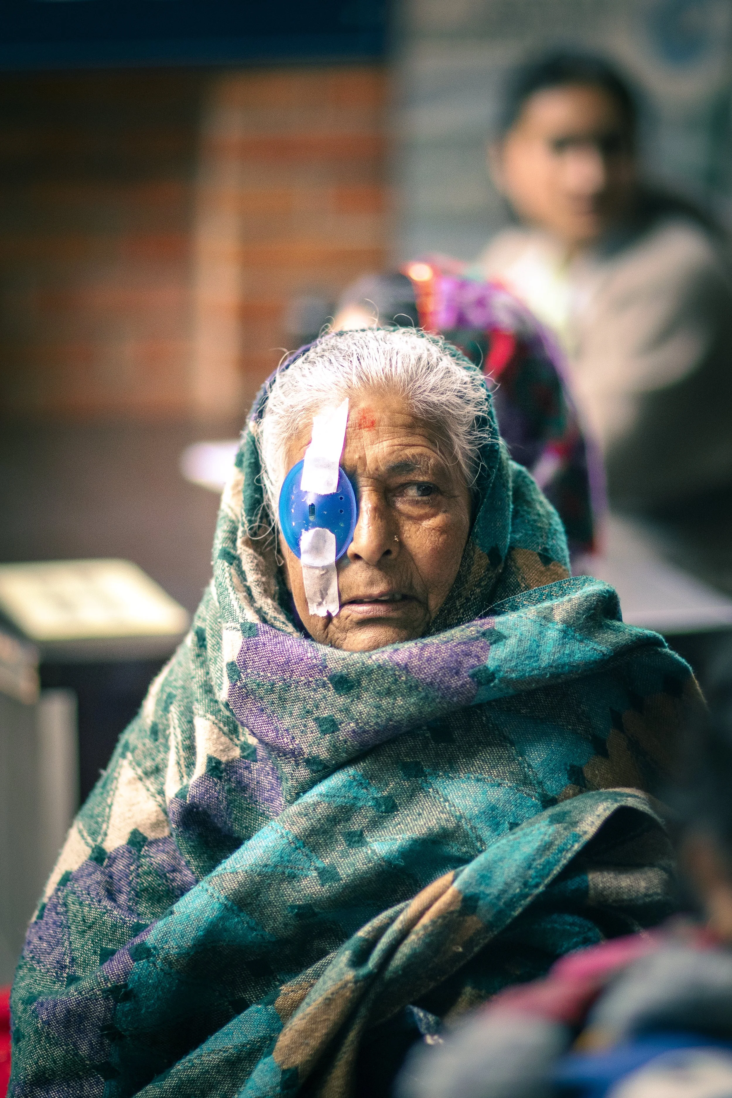 Elderly Nepalese woman post surgery bandage eye portrait Tilganga Eye Institute Kathmandu Nepal Simon Shattky
