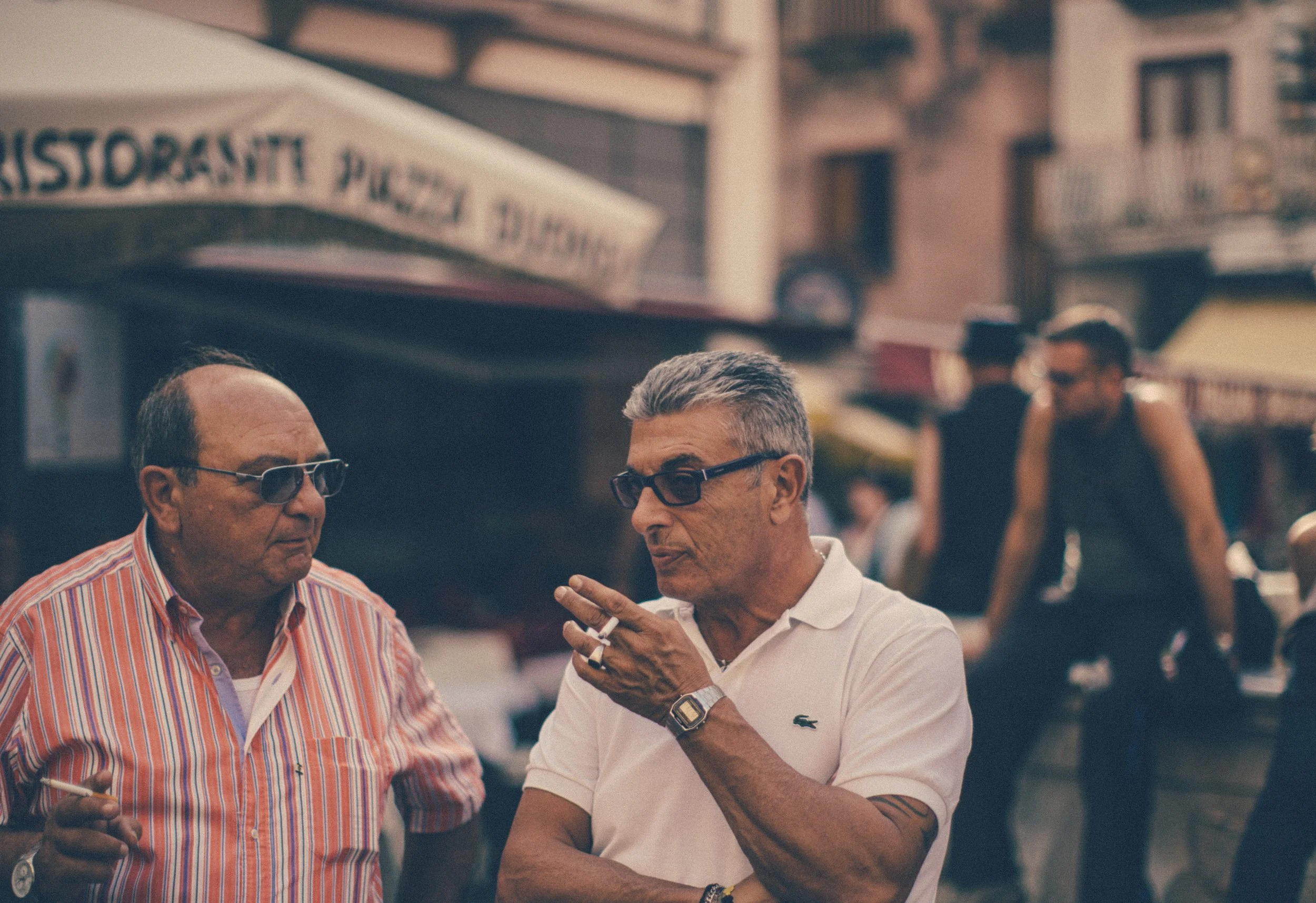 Candid portrait two men smokers in conversation Amalfi coast Italy street scene Simon Shattky
