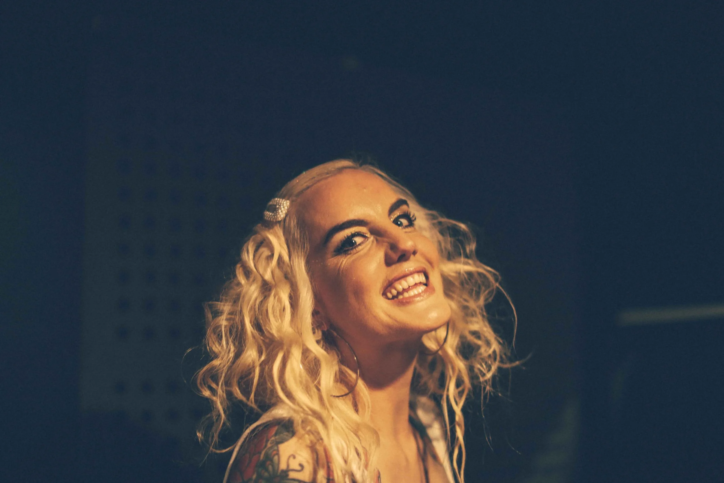 Editorial portrait woman blonde singer olwyn hopley at gig dramatic lighting Simon Shattky
