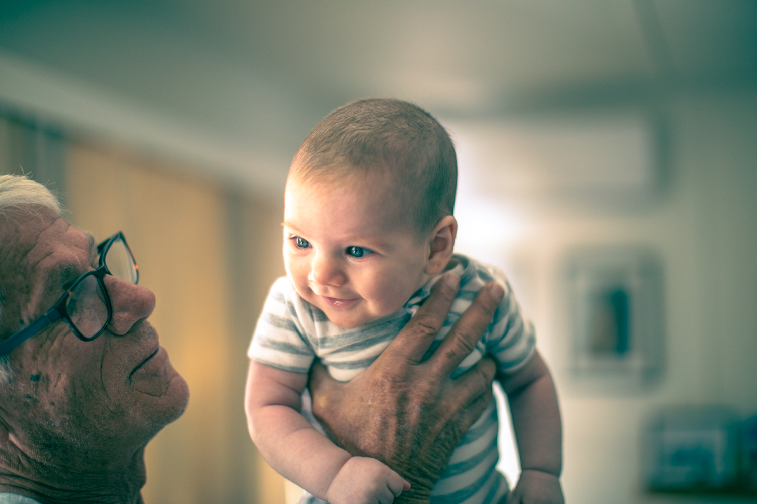 Candid portrait young baby held in grandfather Al Groves hand natural light indoor Simon Shattky
