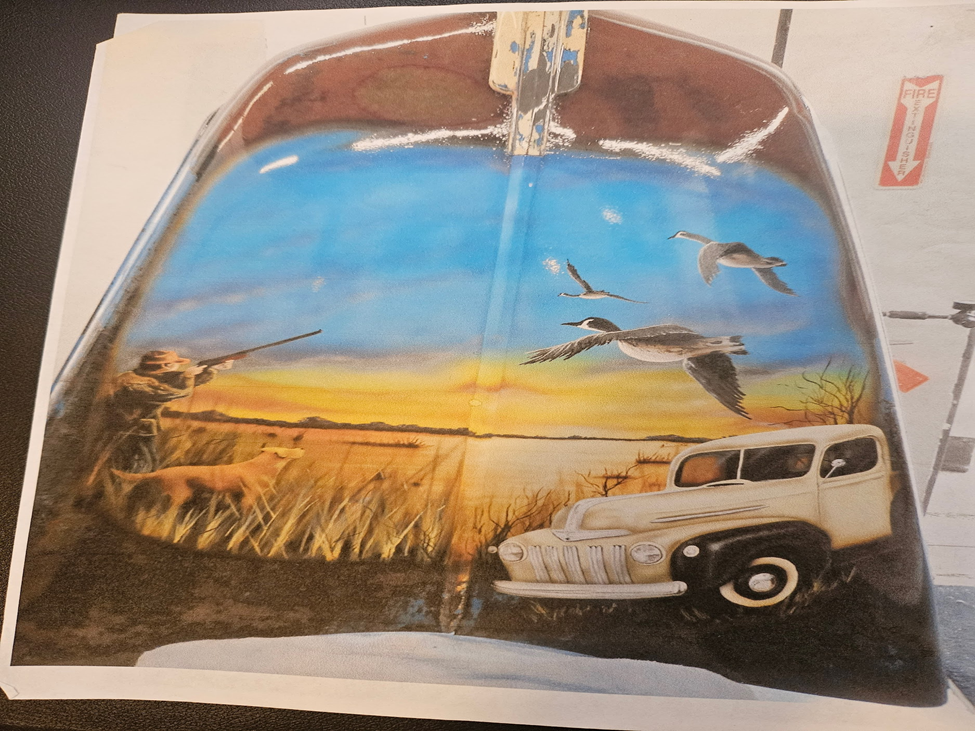 Custom airbrush hunting scene on car hood featuring flying birds, hunter, and vintage truck in sunset landscape