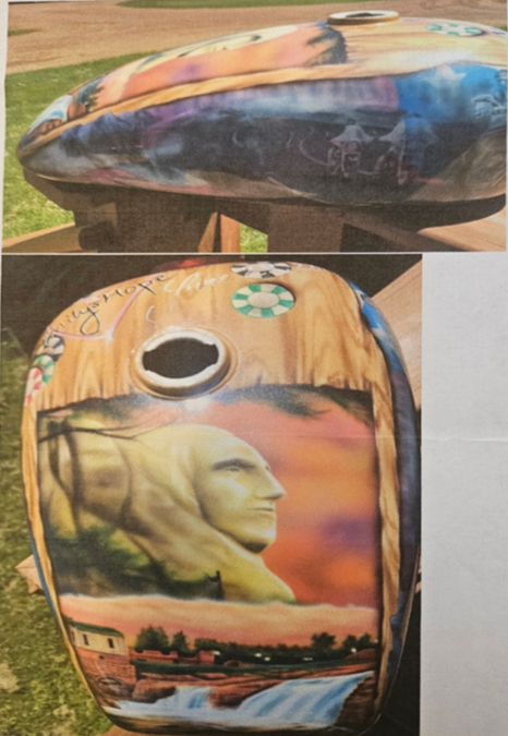 Custom airbrush motorcycle gas tank with portrait artwork and landscape scene in warm sunset tones