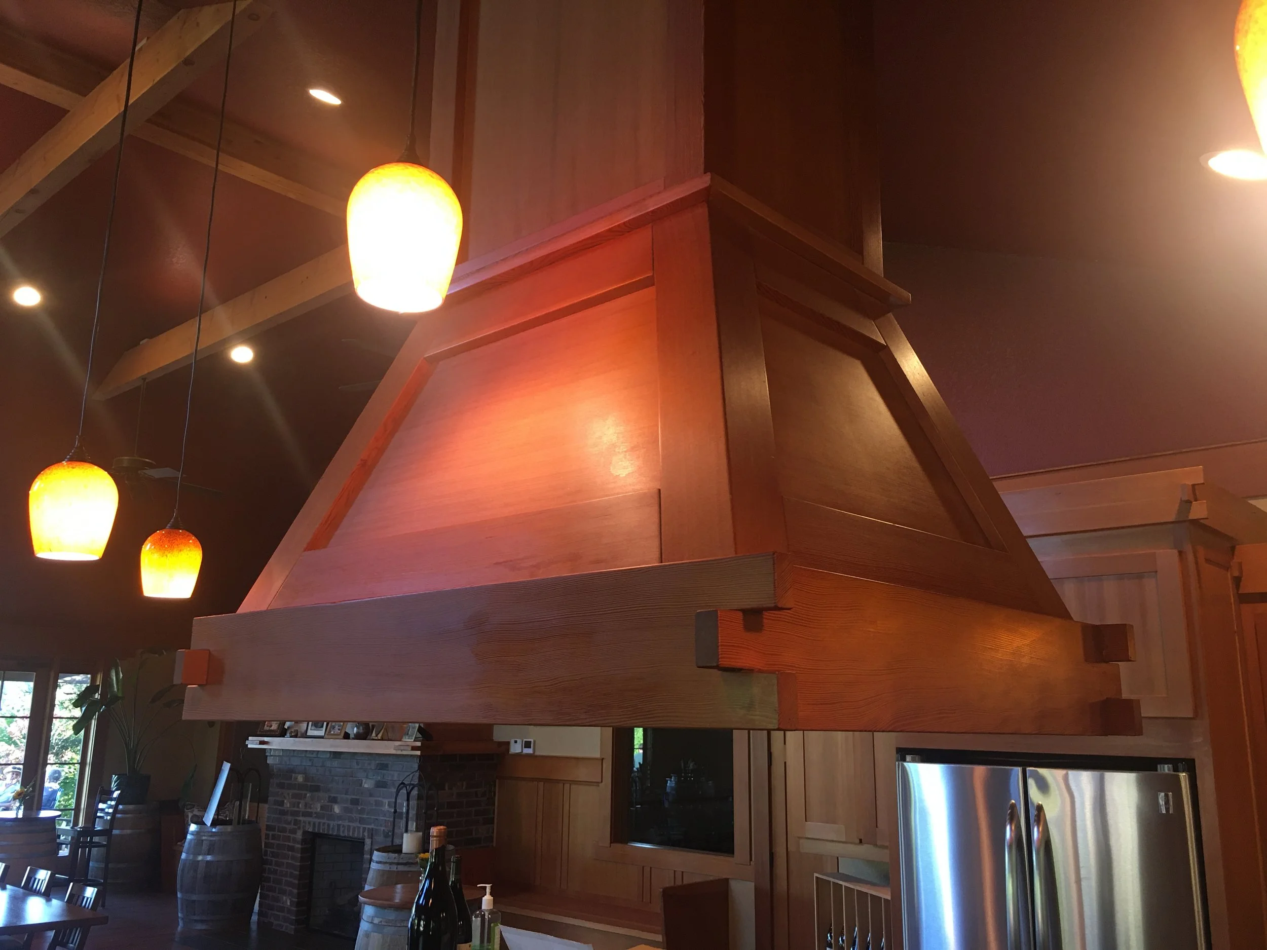 Ark Built Carpentry custom vent hood surrounded by tools and materials, including a workbench, power tools, and shelving. I