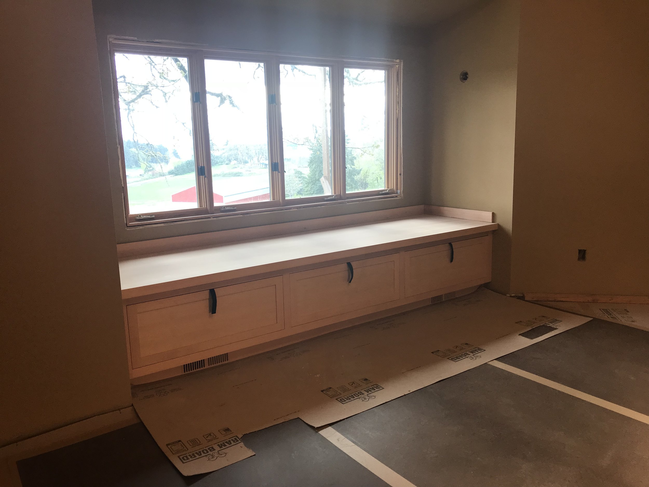 Ark Built Carpentry custom designed wooden built-in cabinet under the window.