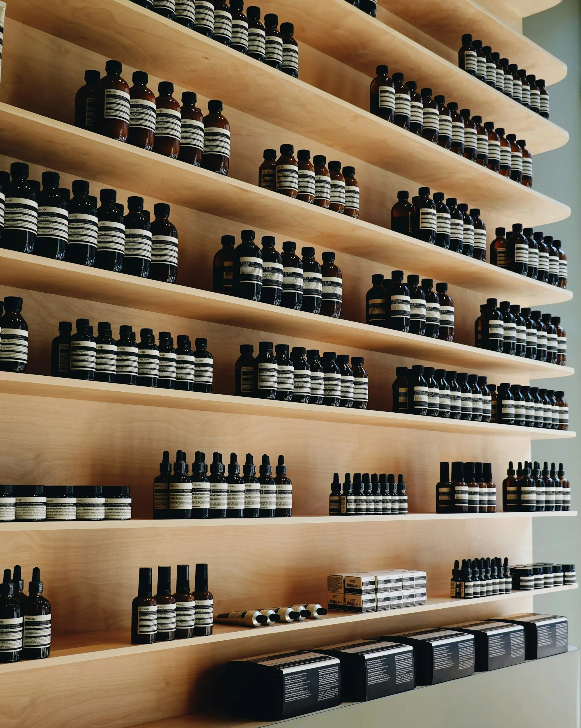 Estantes de madera llenas de frascos y botellas de medicamentos o productos en una farmacia o tienda naturista.