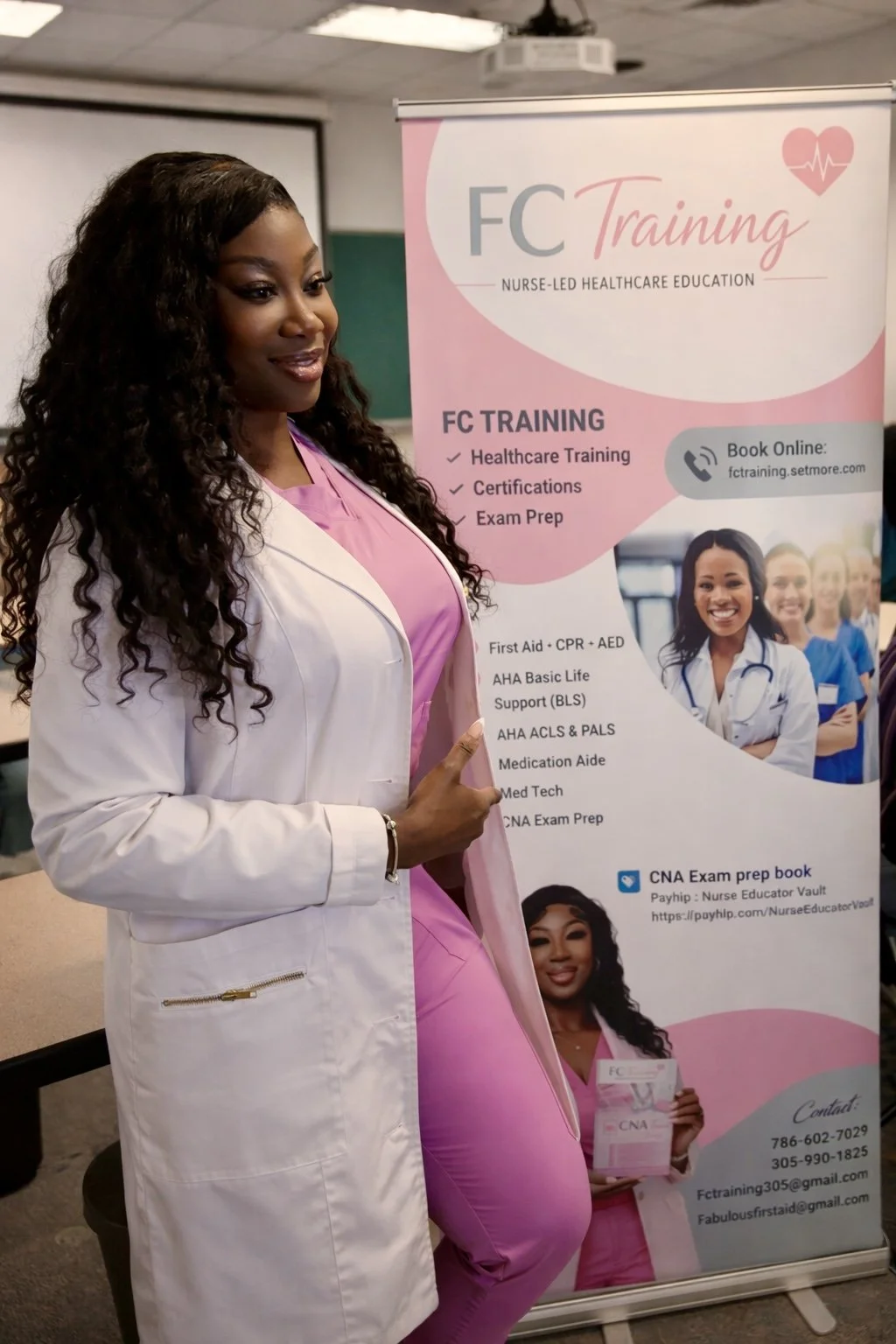 A woman in a white medical coat and pink scrubs standing next to a pink and white banner promoting FC Training, a nurse-led healthcare education program. The banner lists training programs like healthcare training, certifications, exam prep, and includes contact information.