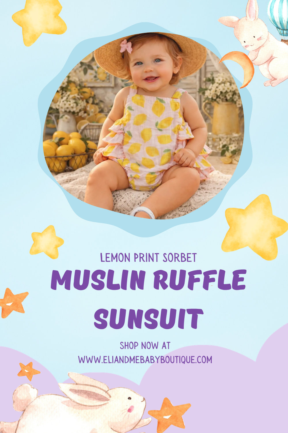 A smiling baby girl with curly hair, wearing a lemon print sleeveless romper and a sun hat, sitting on a blanket in front of a display of lemons and flowers.