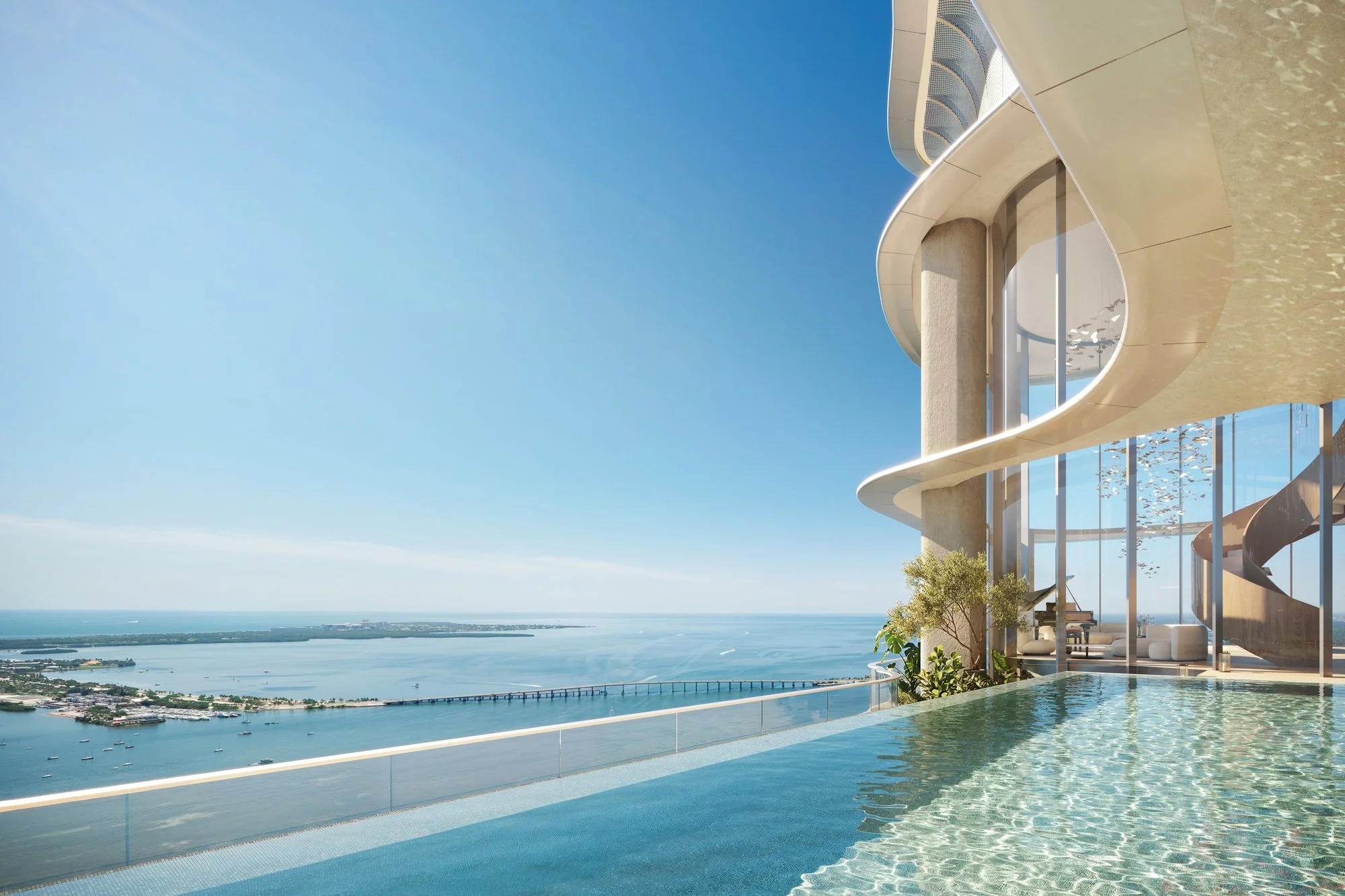 Modern beachfront building with an infinity pool overlooking the ocean on a sunny day.