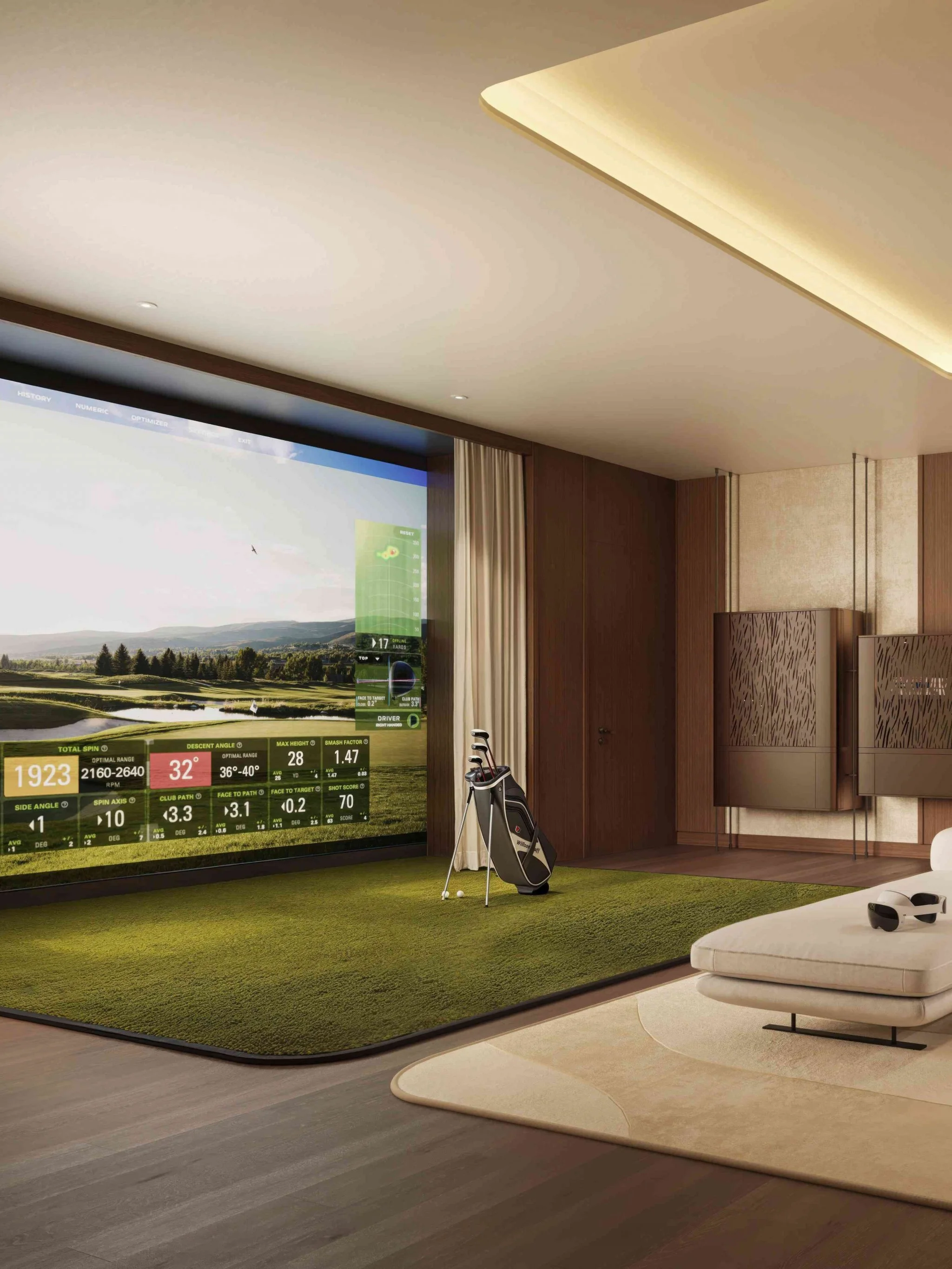 A home golf simulator room featuring a large screen displaying a golf course, a golf bag with clubs, a sofa with headphones, and a green carpeted area for swinging golf shots.