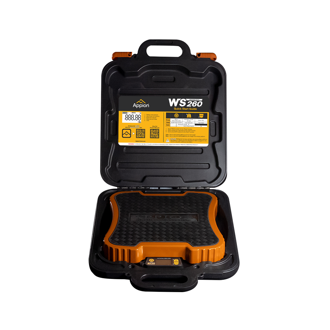 Open black and orange case containing a digital device for measuring weight, with a yellow label on the inner lid showing instructions and information.