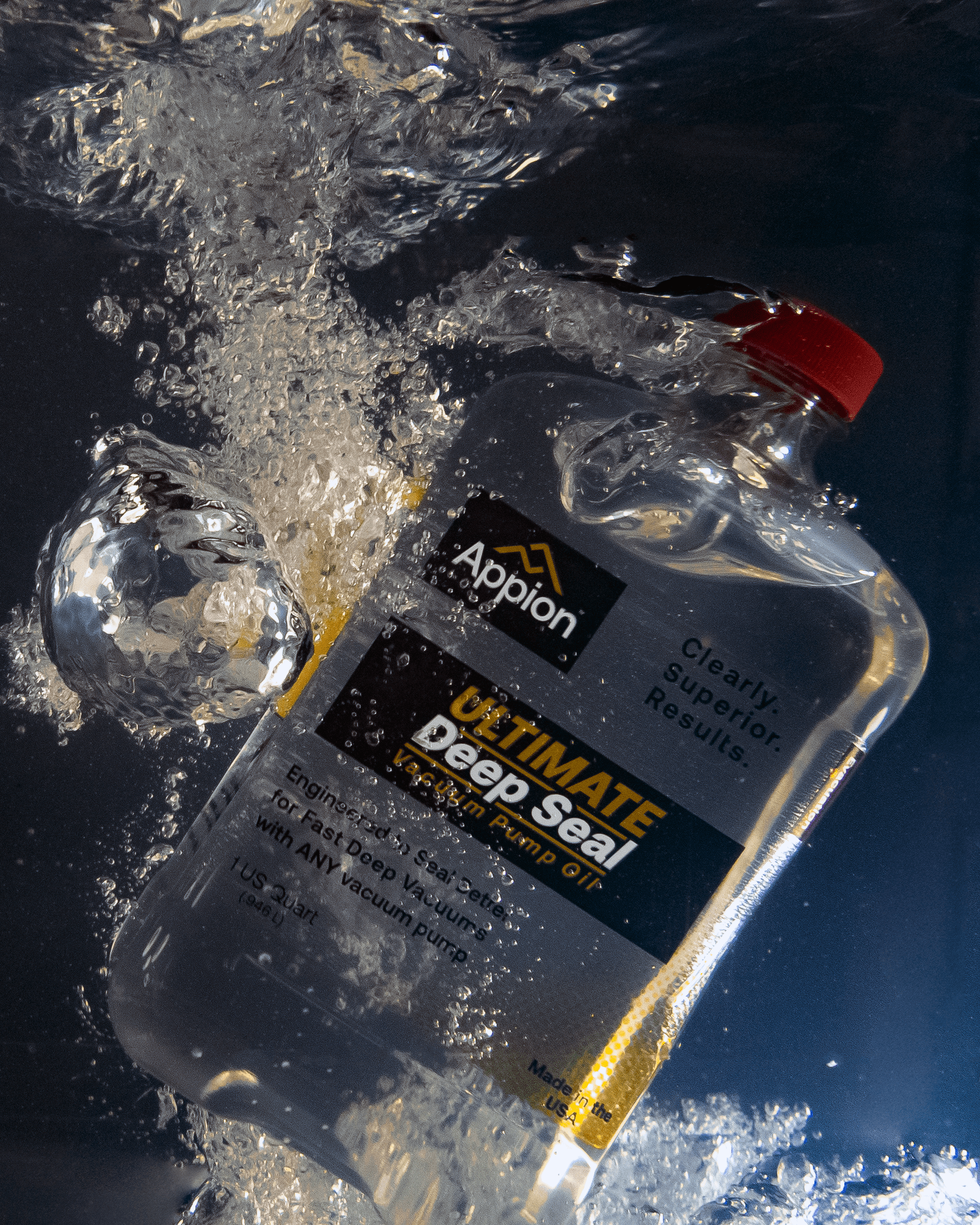 A clear plastic bottle of Appion Ultimate Deep Seal Vacuum Pump Oil submerged in water with bubbles and splash effects.